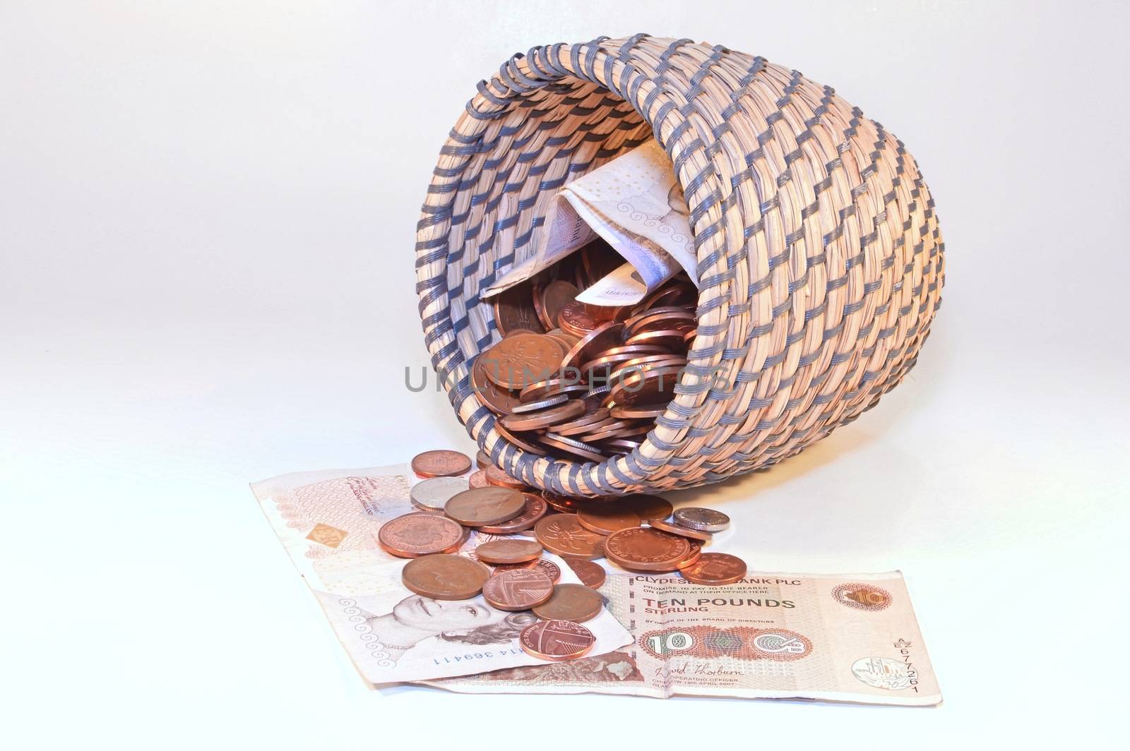coins in basket and british banknotes