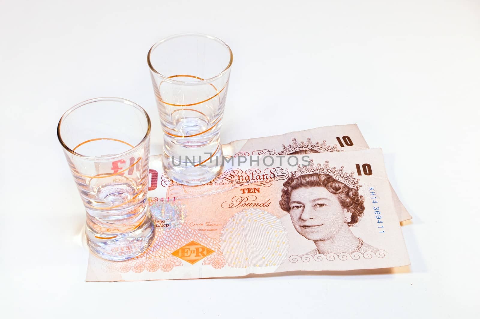 two vodka glasses on banknotes ten pounds