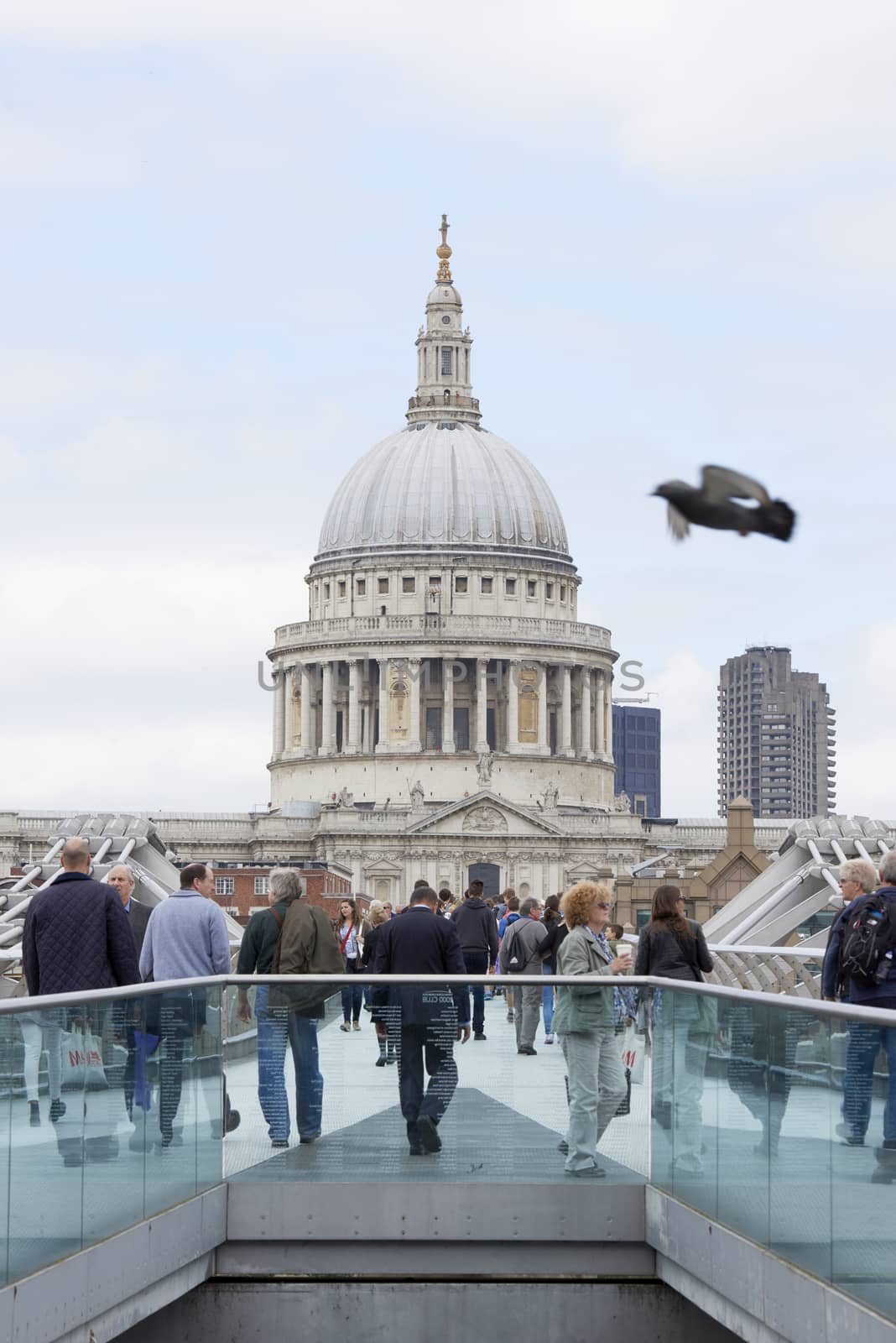 LONDON, UK - JUNE 23: Dome of Saint Paul's cathedral, with people crossing Millennium Bridge in the foreground. June 23, 2015 in London.