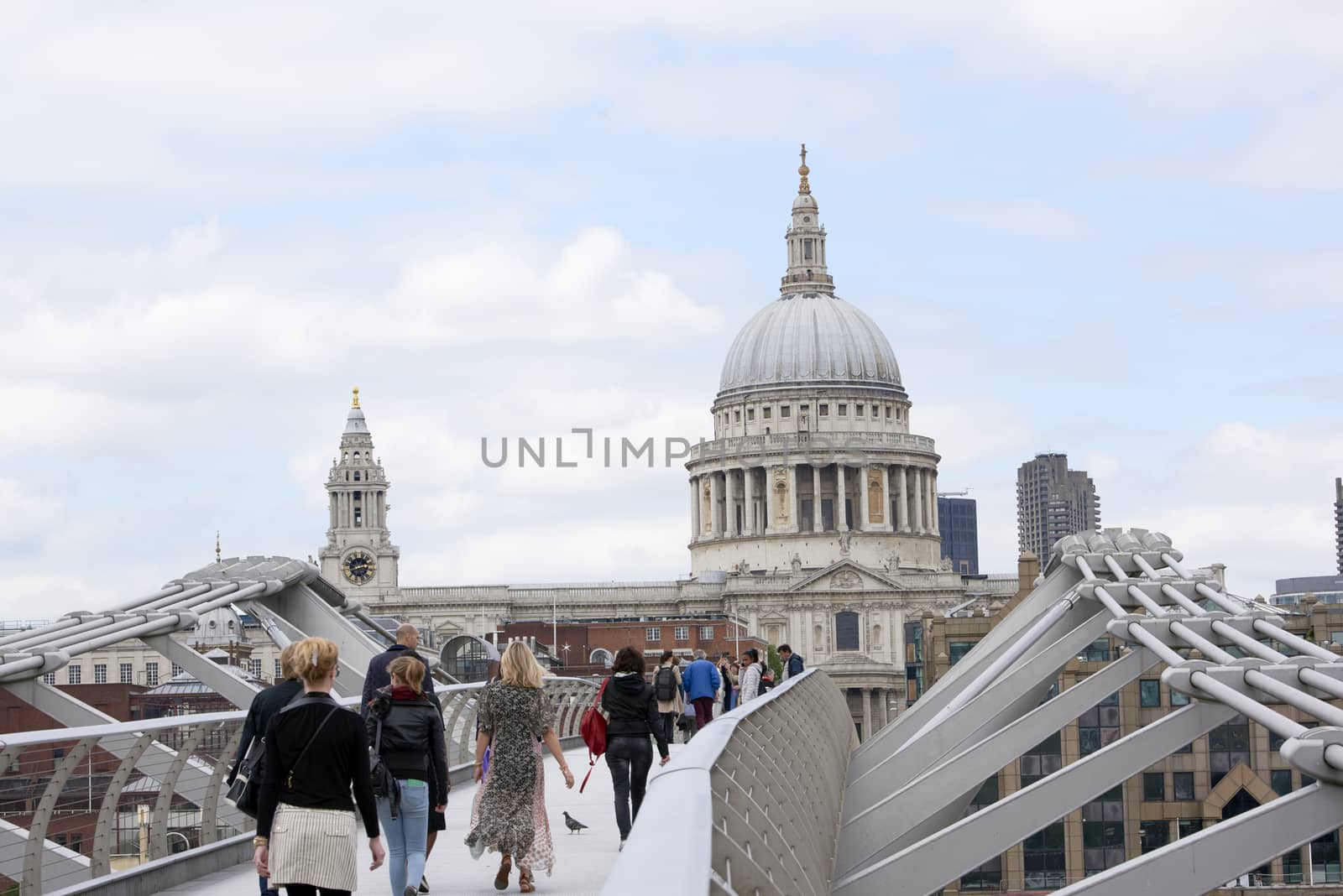 LONDON, UK - JUNE 23: Dome of Saint Paul's cathedral, with people crossing Millennium Bridge in the foreground. June 23, 2015 in London.