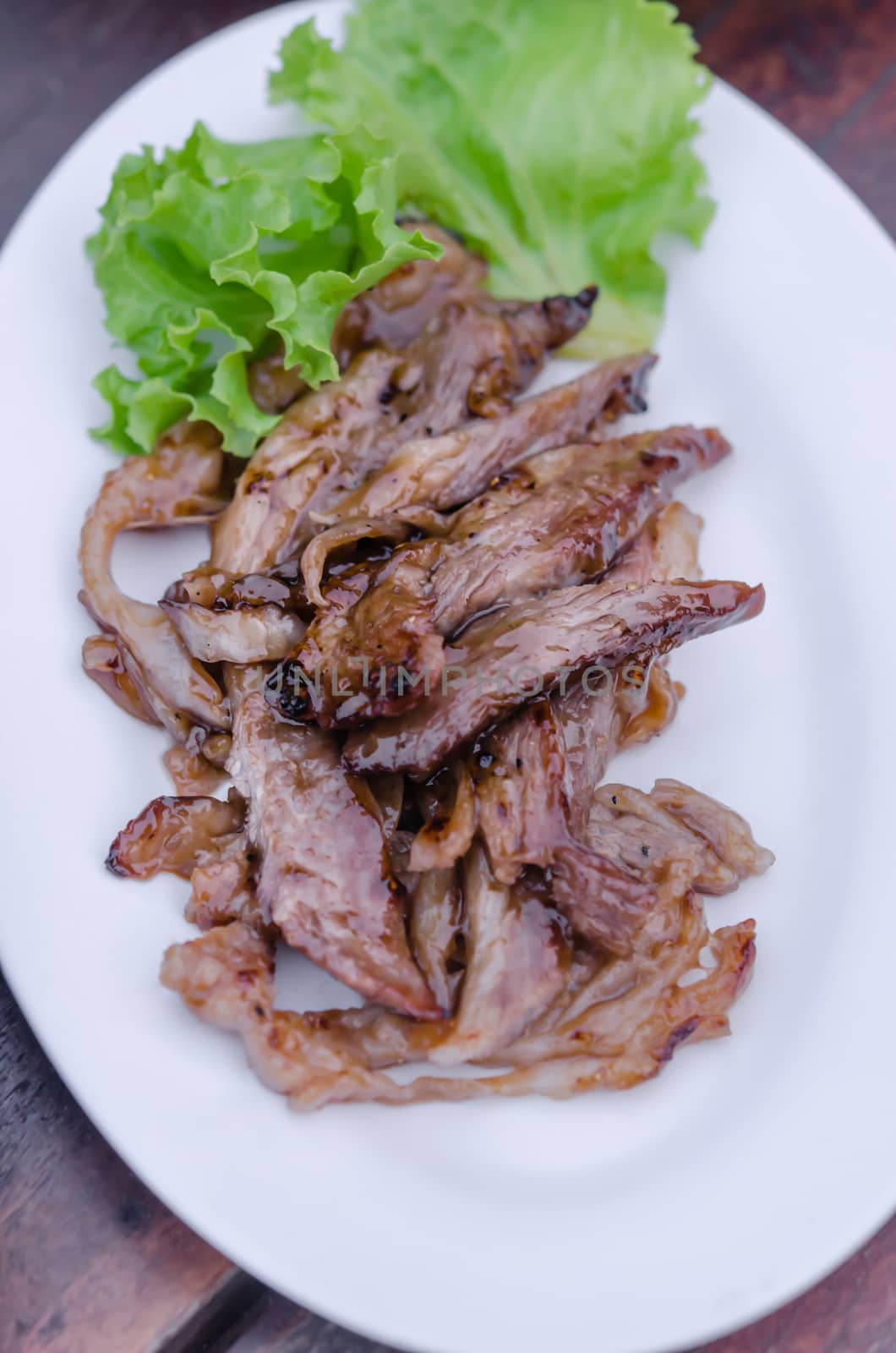 Sliced grilled Beef with fresh lettuce on dish