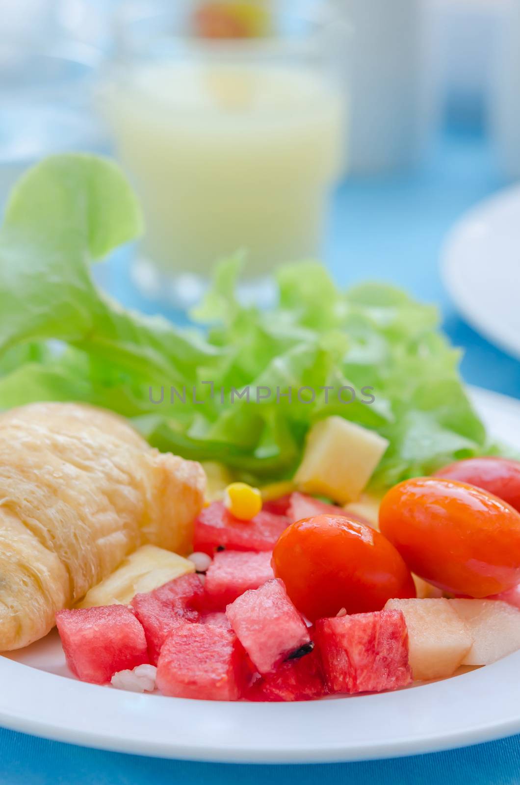 A breakfast croissant with mix fruit salad