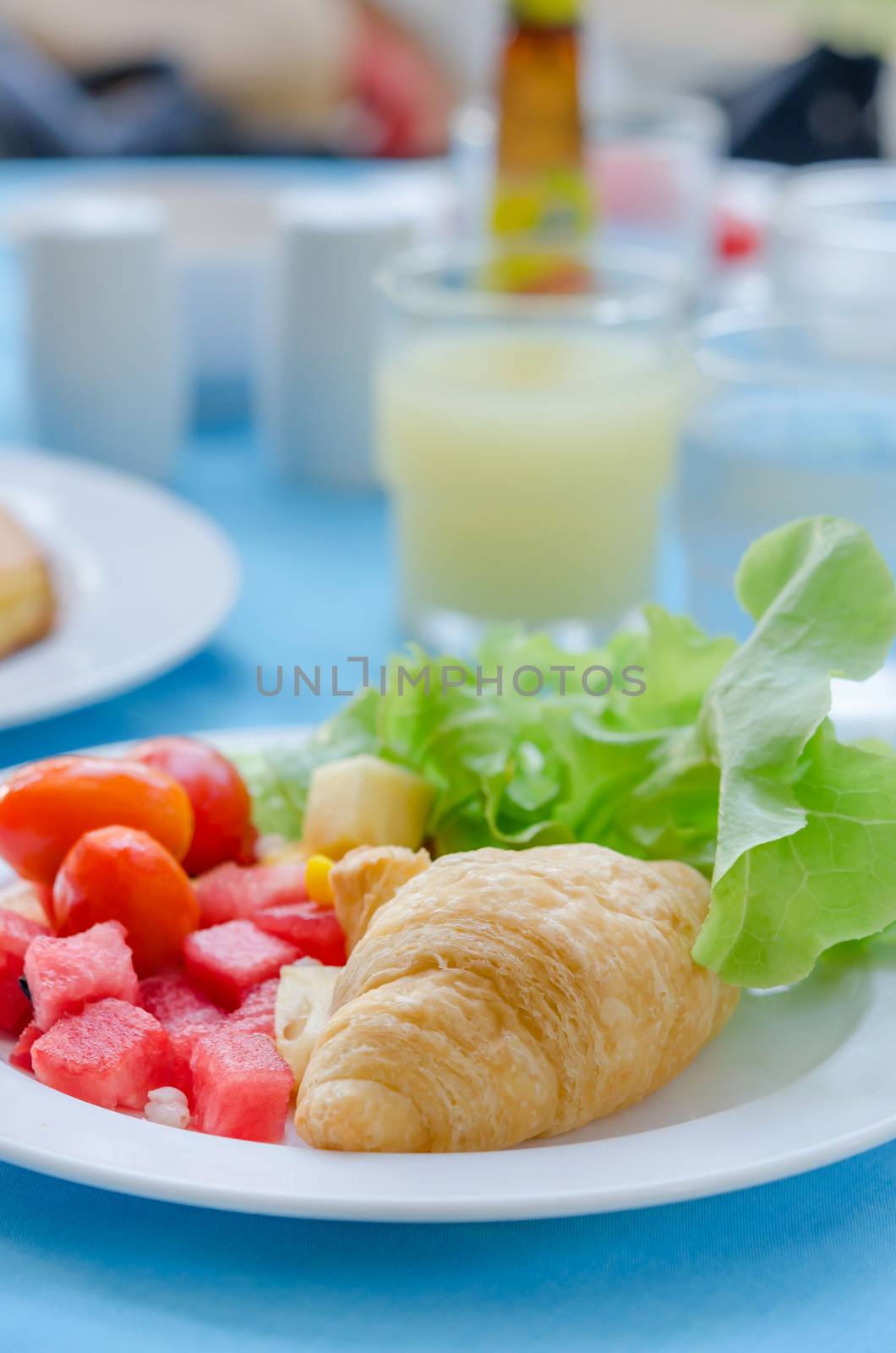 A breakfast croissant with mix fruit salad