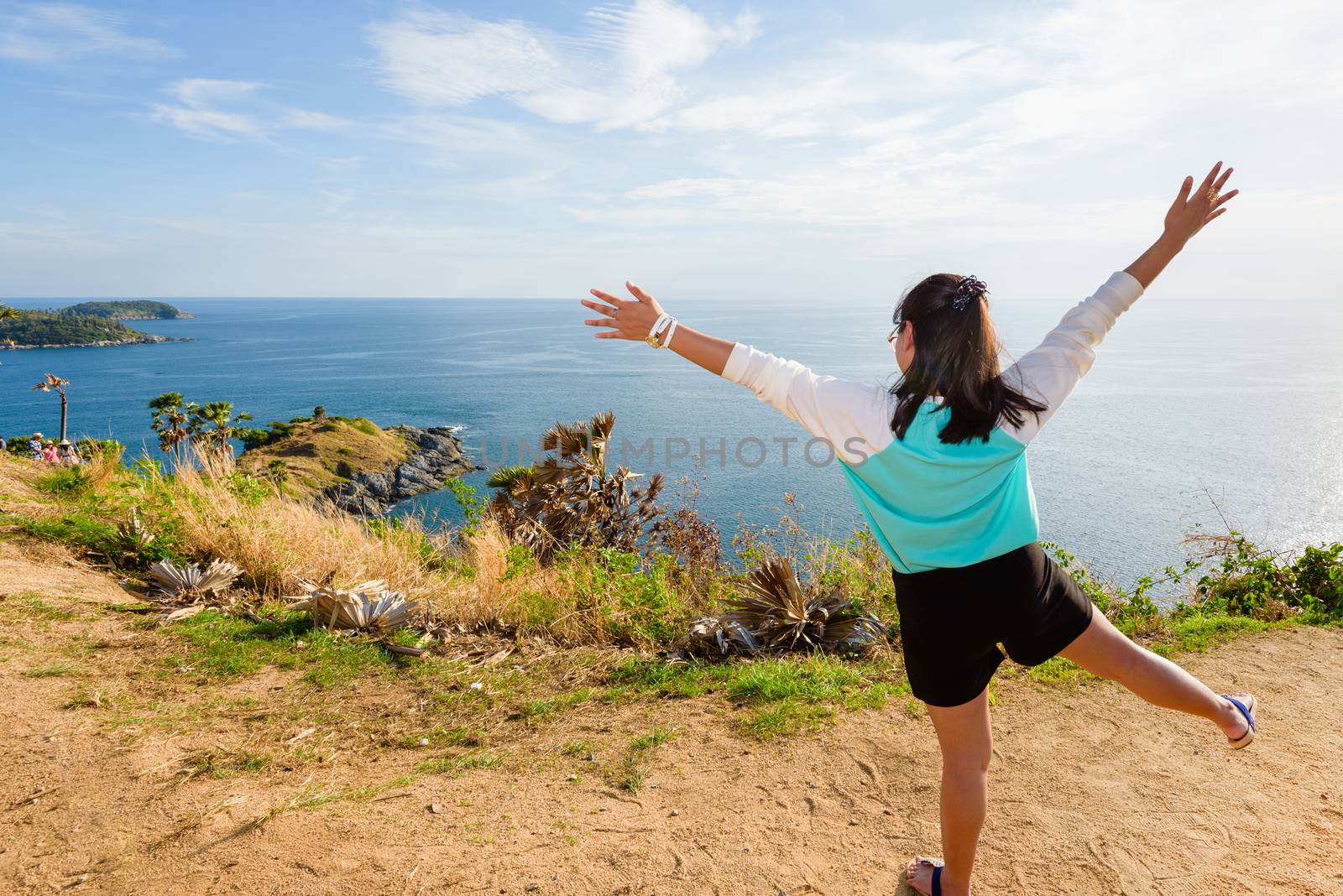 Back of the woman tourist looking ocean views and expressions of joy on the mountain at Cape Phromthep viewpoint a famous attractions of Phuket Province in Thailand