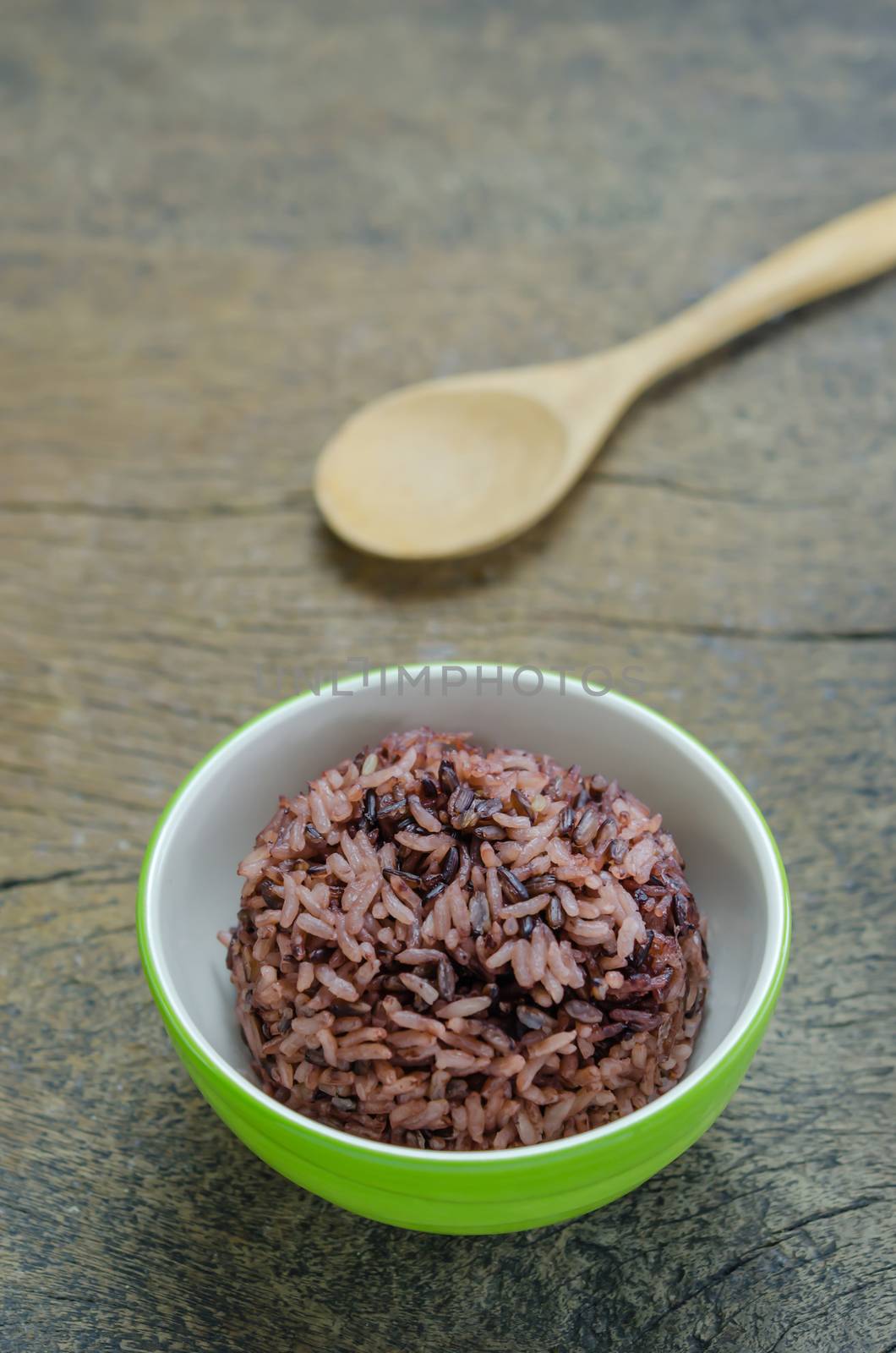 Cooked rice of Riceberry in green bowl on wooden table