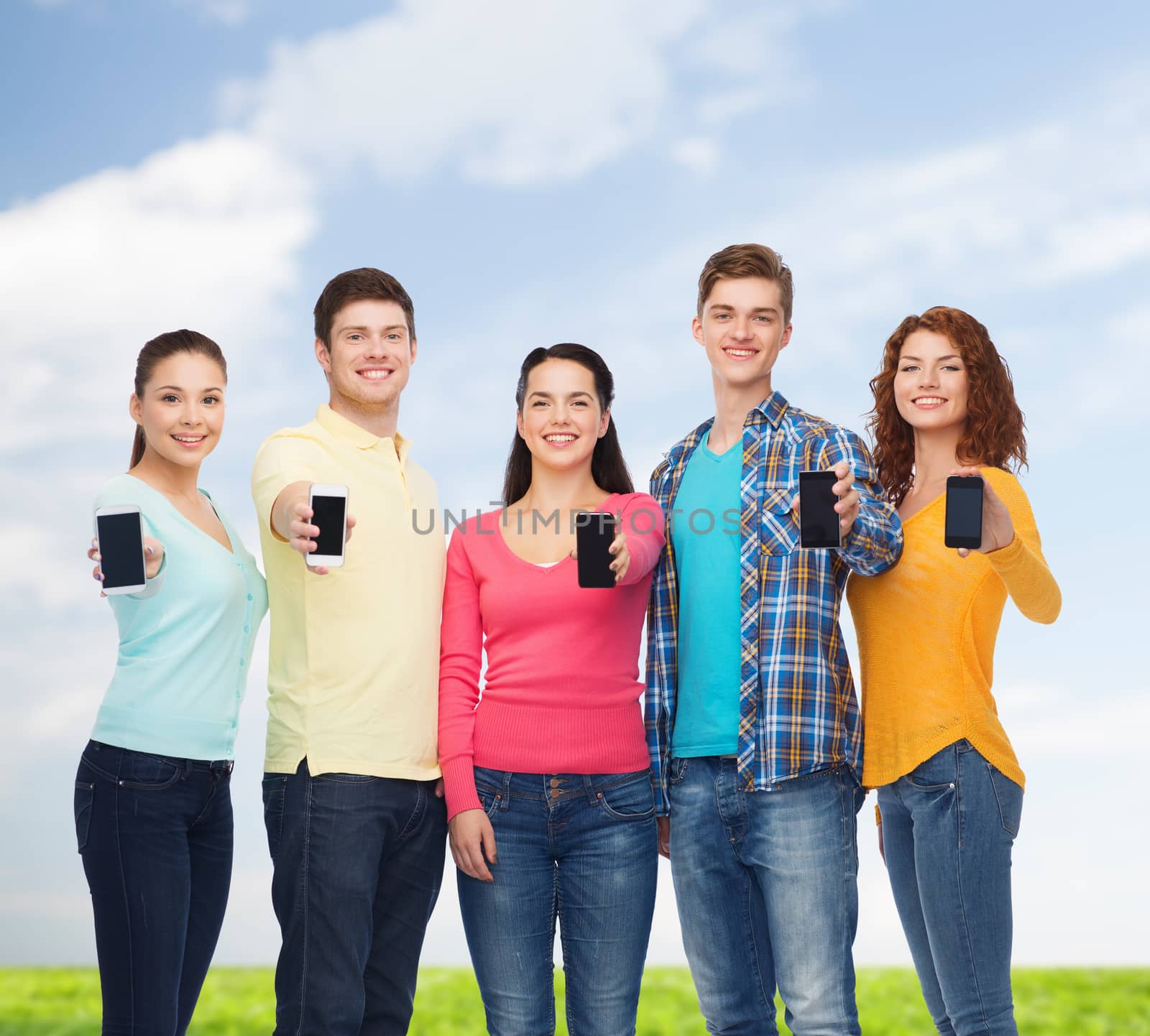 group of smiling teenagers with smartphones by dolgachov