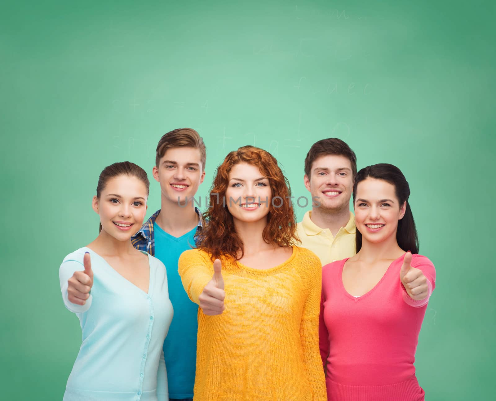 group of smiling teenagers over green board by dolgachov