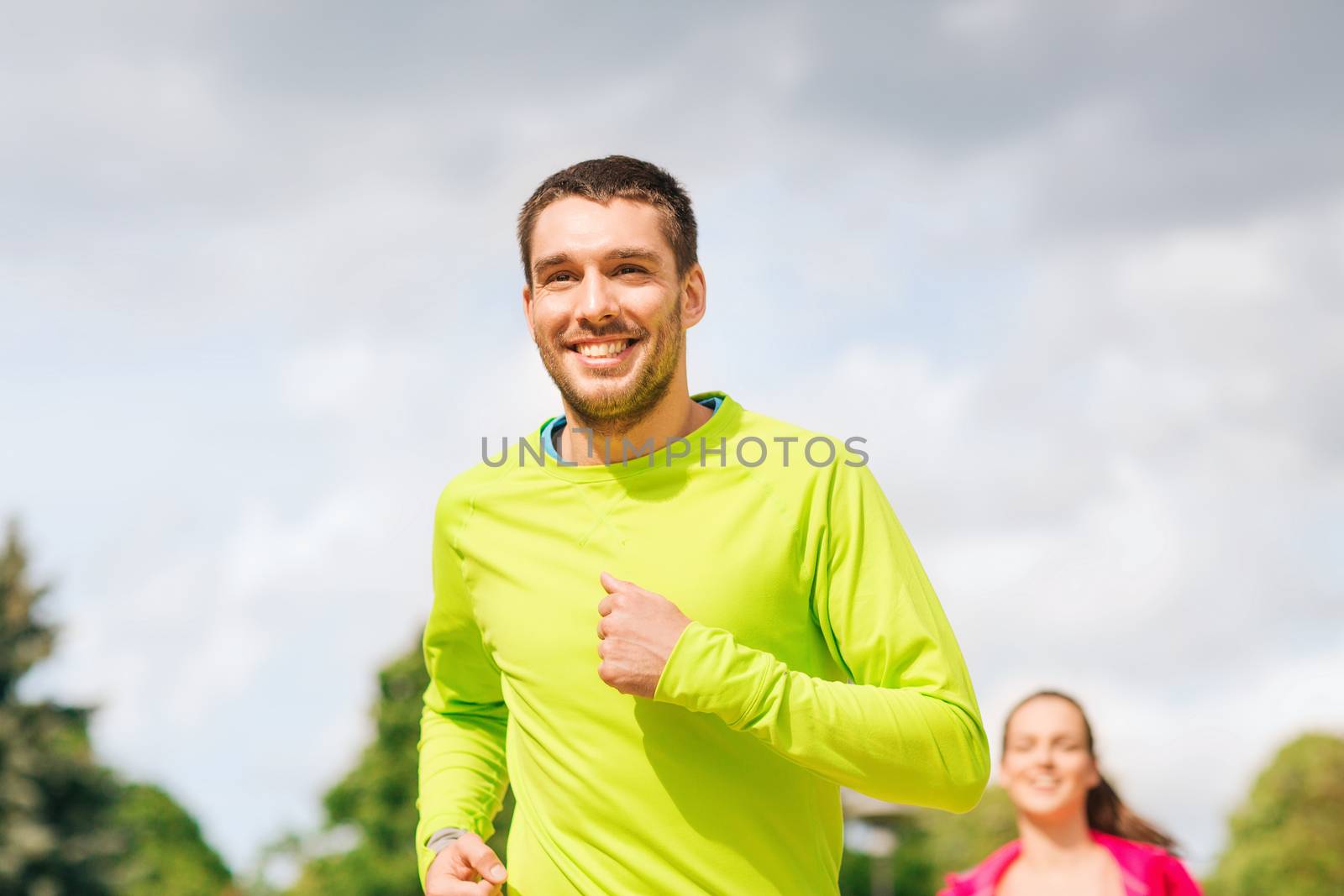 smiling couple running outdoors by dolgachov