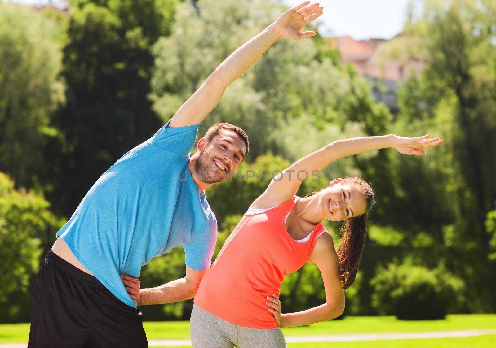 smiling couple stretching outdoors by dolgachov