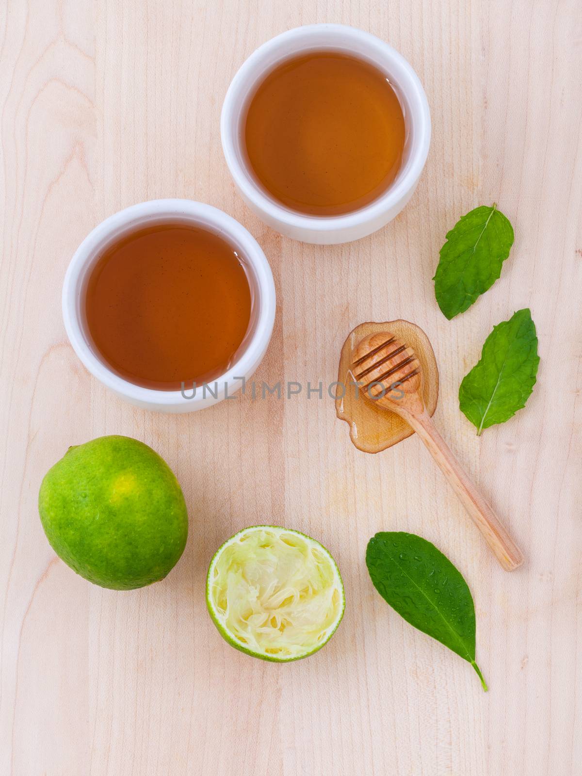 Cups of herbal  tea with aromatic herbal with lemon , lime and honey .