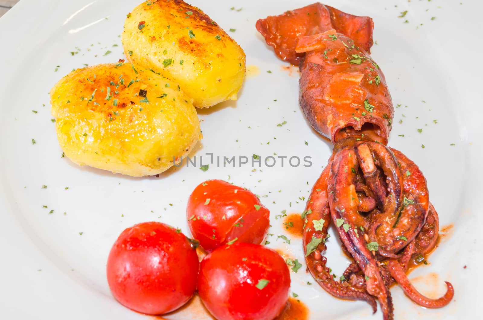 Octopus cooked with potatoes in olive oil - traditional southern dish.