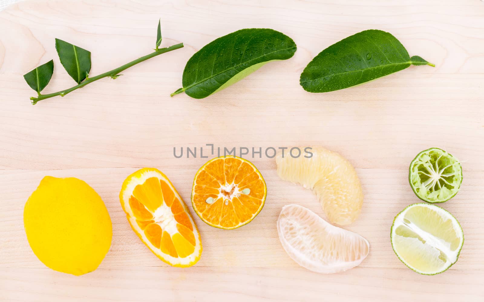 Mixed citruses fruit oranges, pomelo , lemon and lime on wooden background with orange leaf.