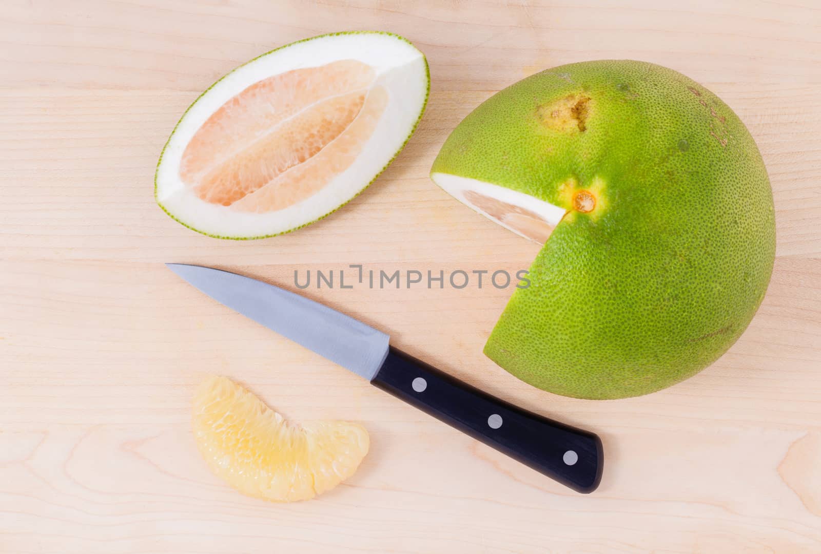 Fresh pomelo cutting and peeled on the wooden background. by kerdkanno