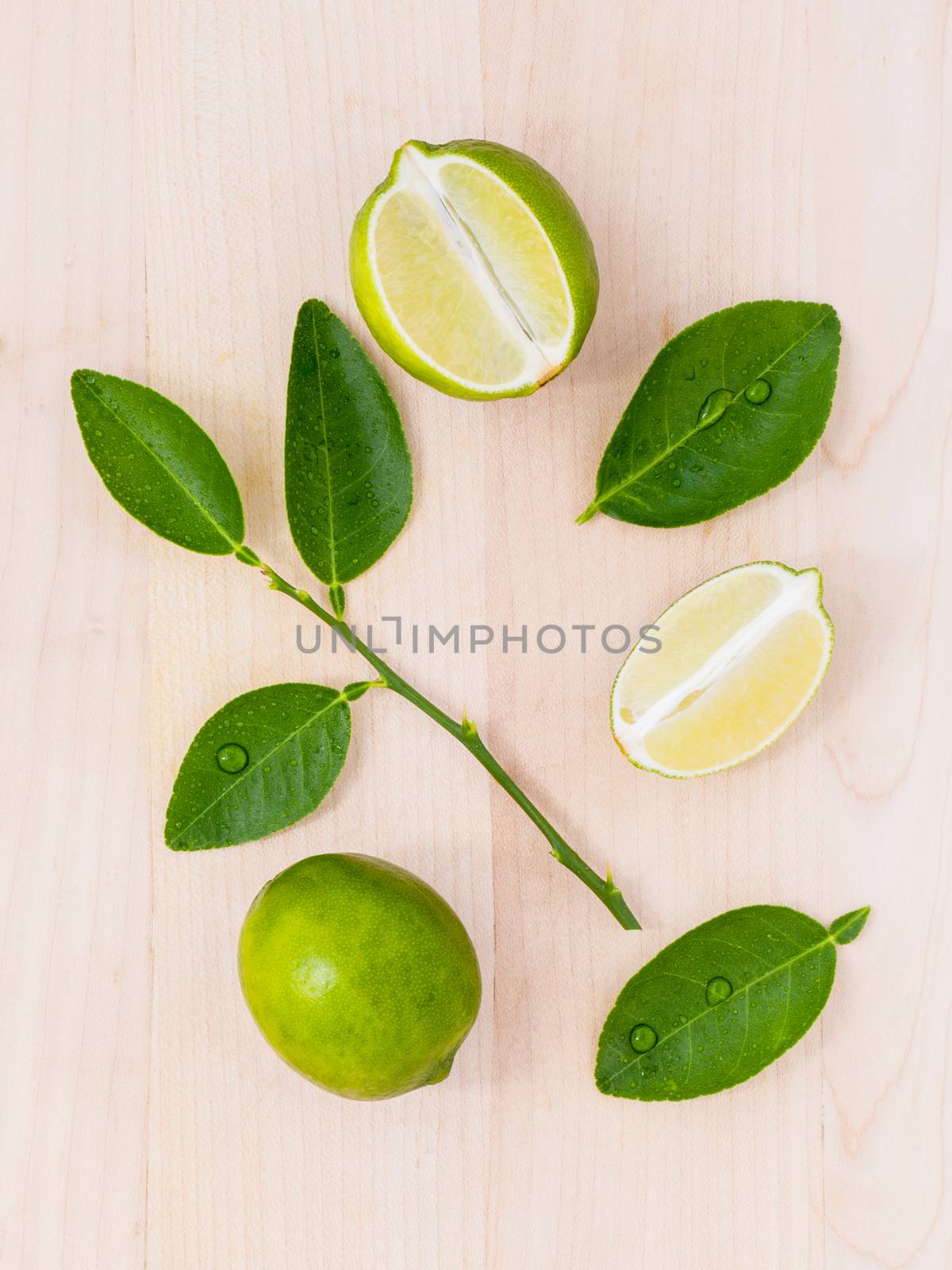 Fresh lime and lime slice on wooden background with  lime leaf. by kerdkanno