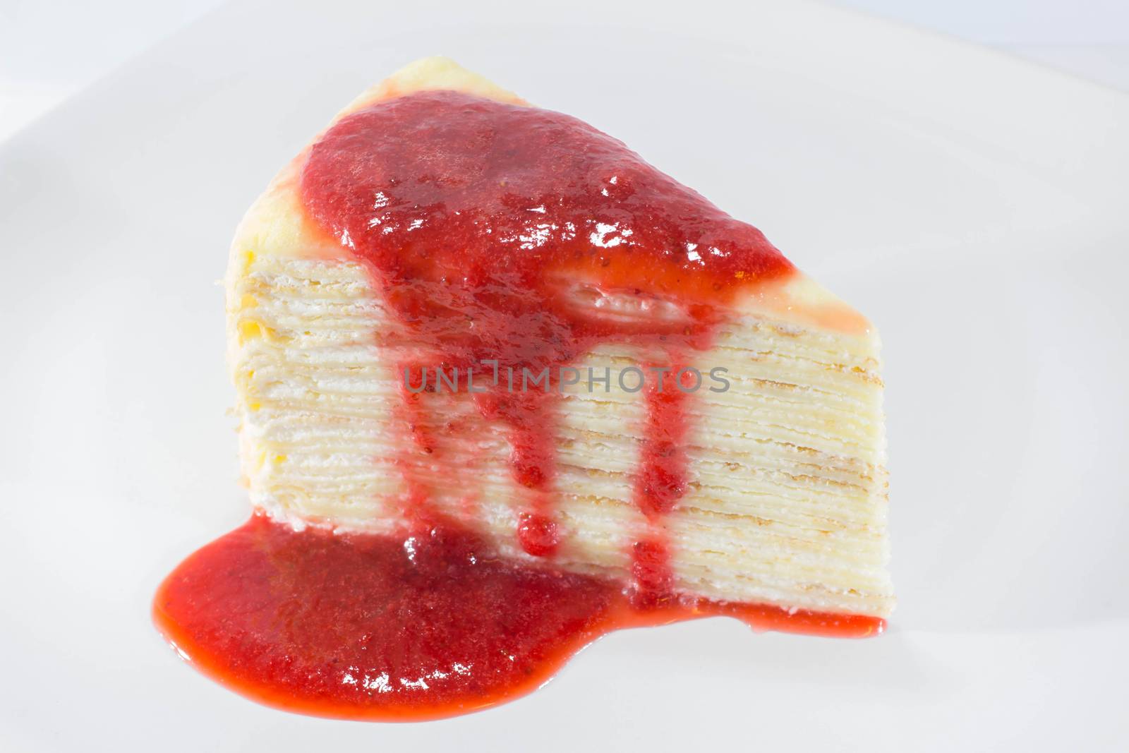 Crepe Cake with strawberry source on dish