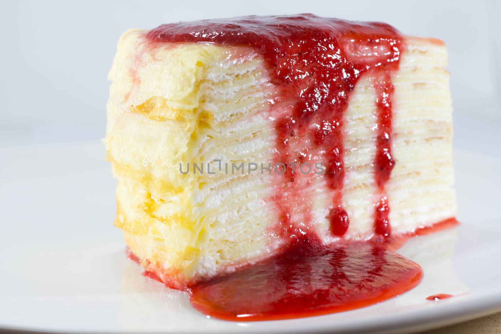 Crepe Cake with strawberry source on dish