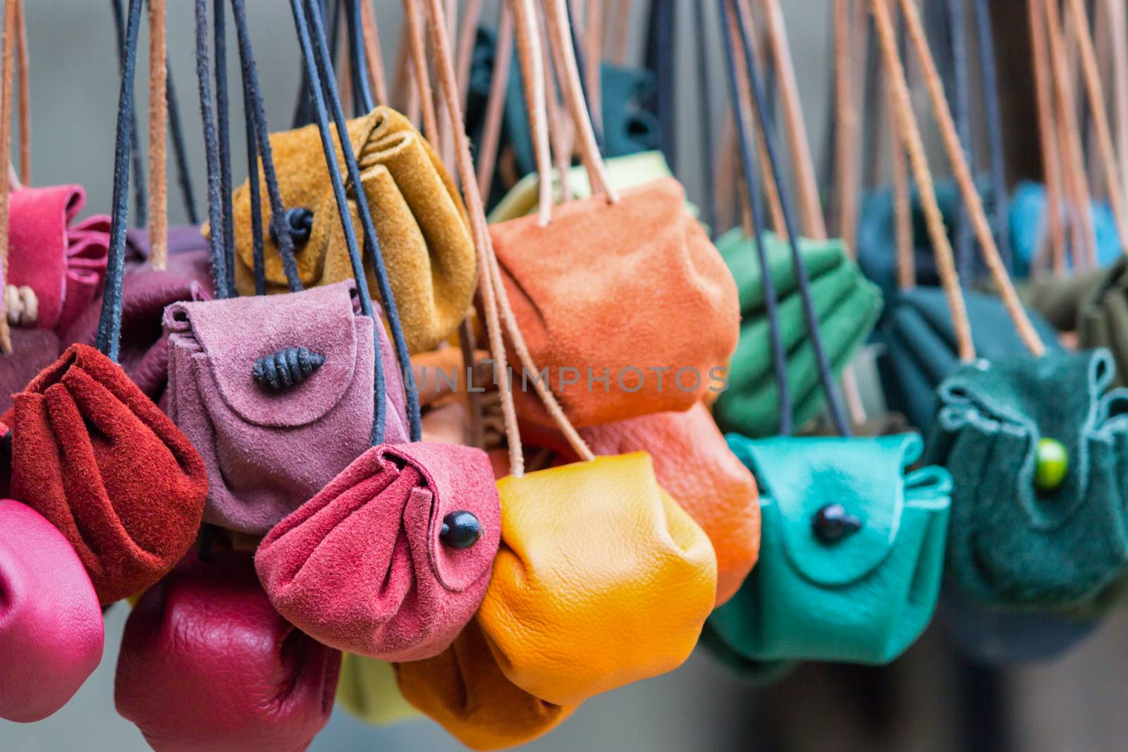 Many various colored moneybags hanging in a row at market