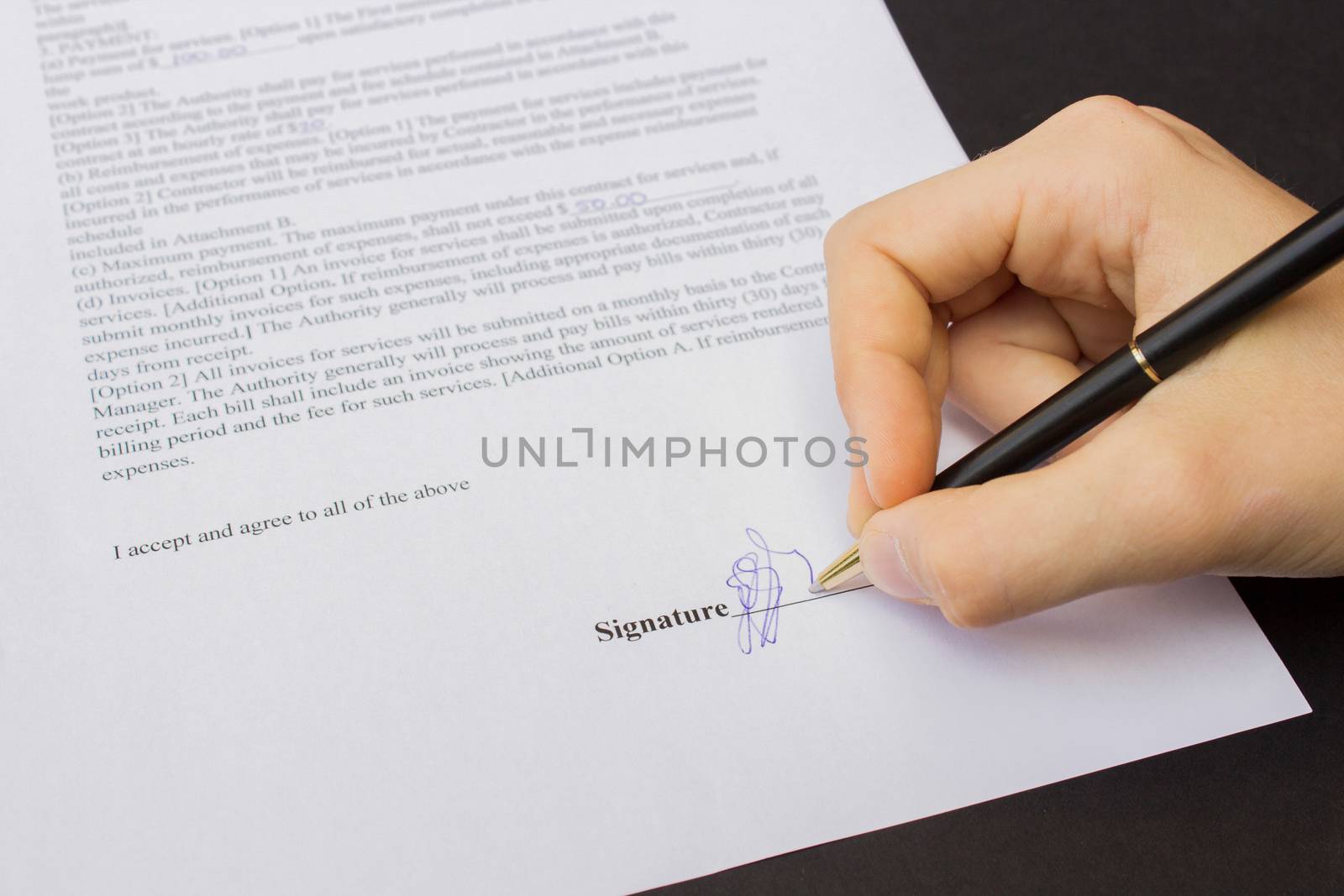 hand holding pen signing a contract