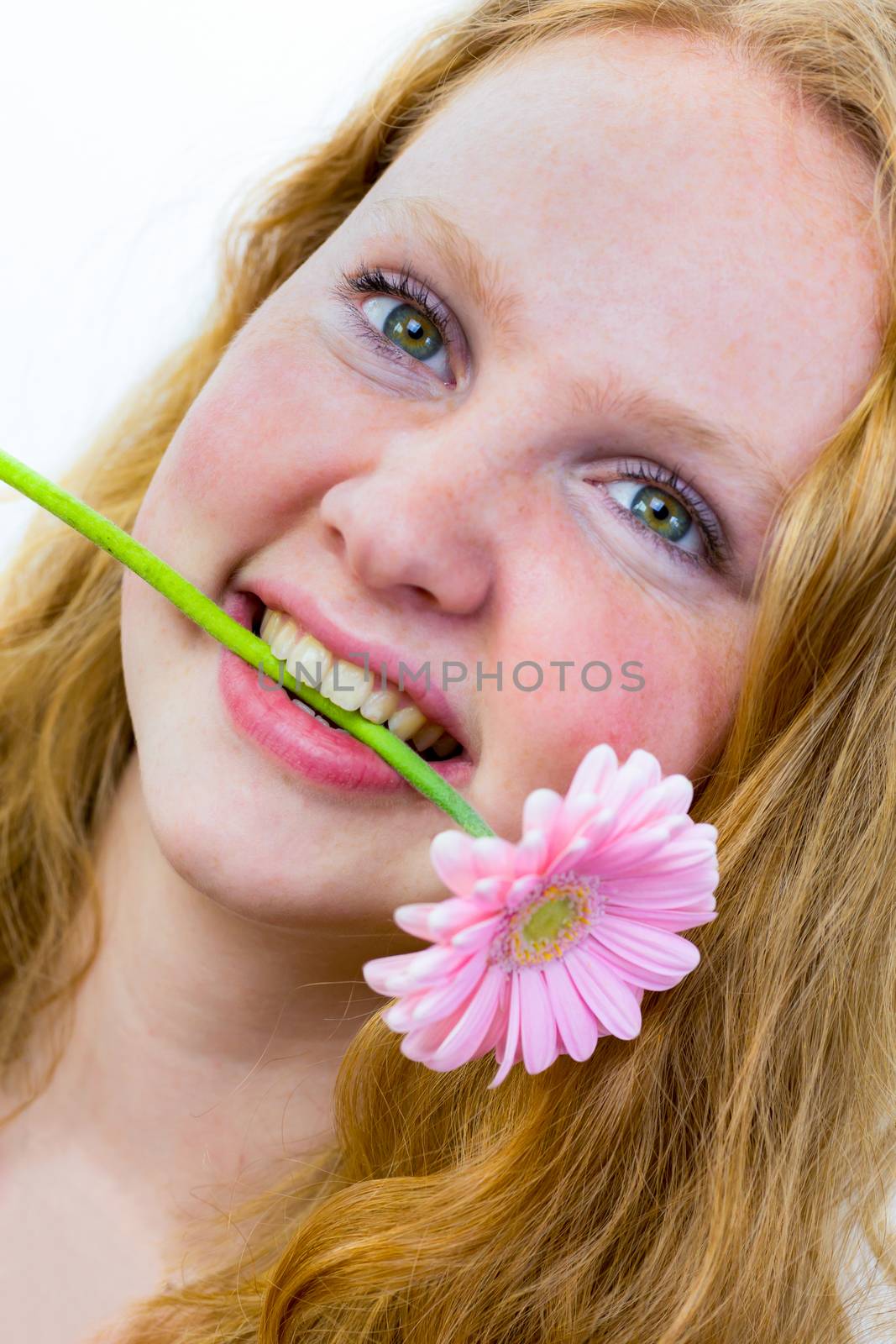 Face of dutch teenage girl with pink flower in her mouth