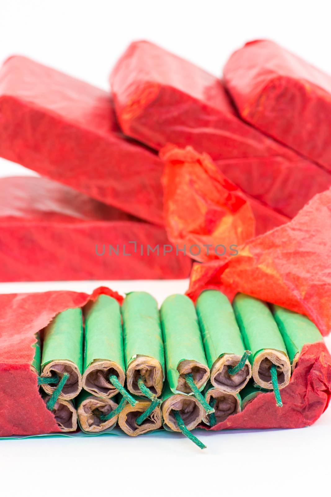 Red packets with stack of green firecrackers isolated on white background