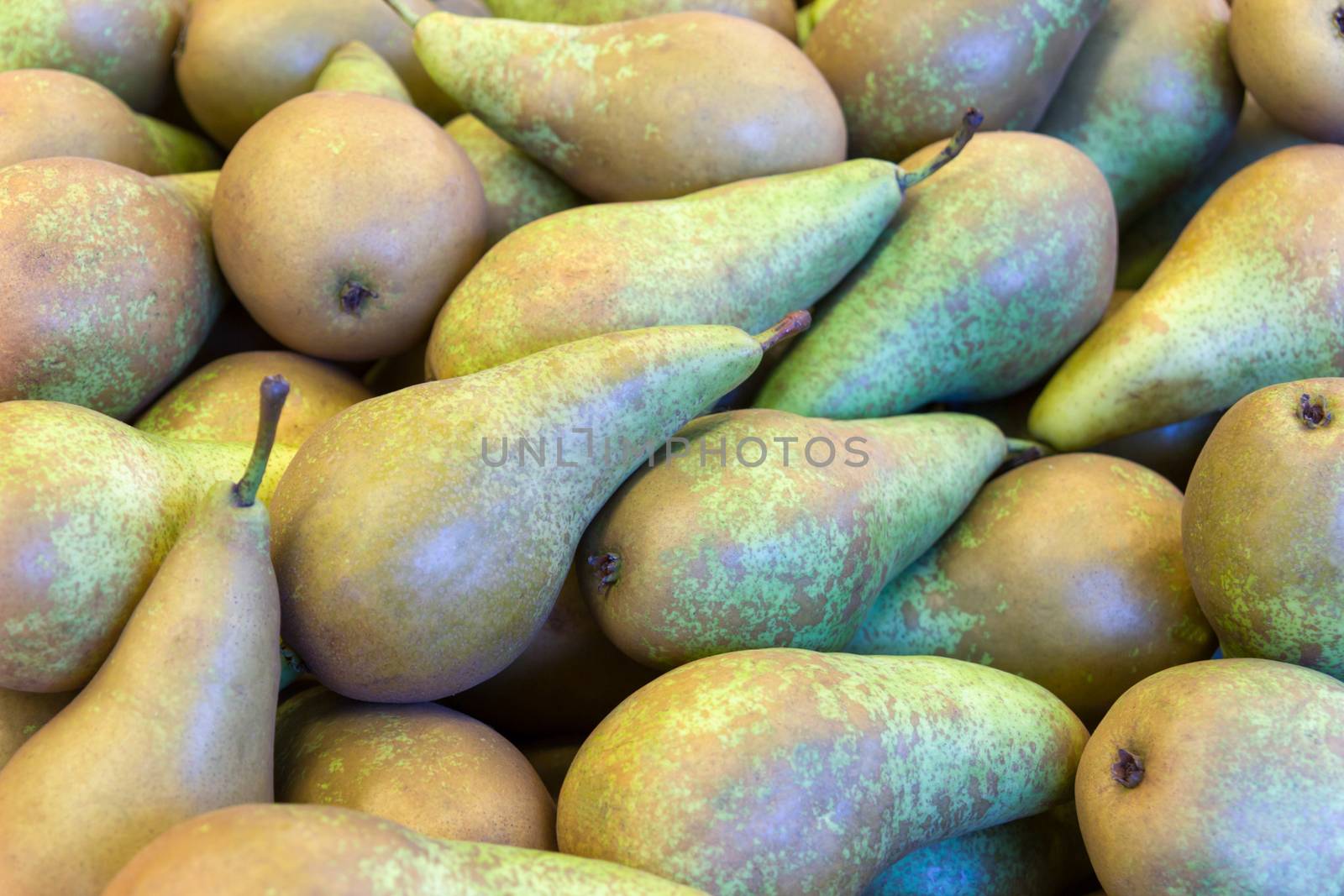 Many stacked green pears at market