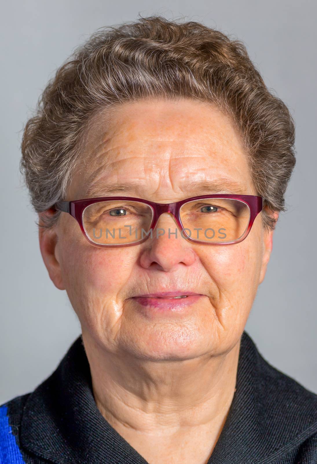 Elderly caucasian  woman wearing spectacles or eye glasses isolated on grey background