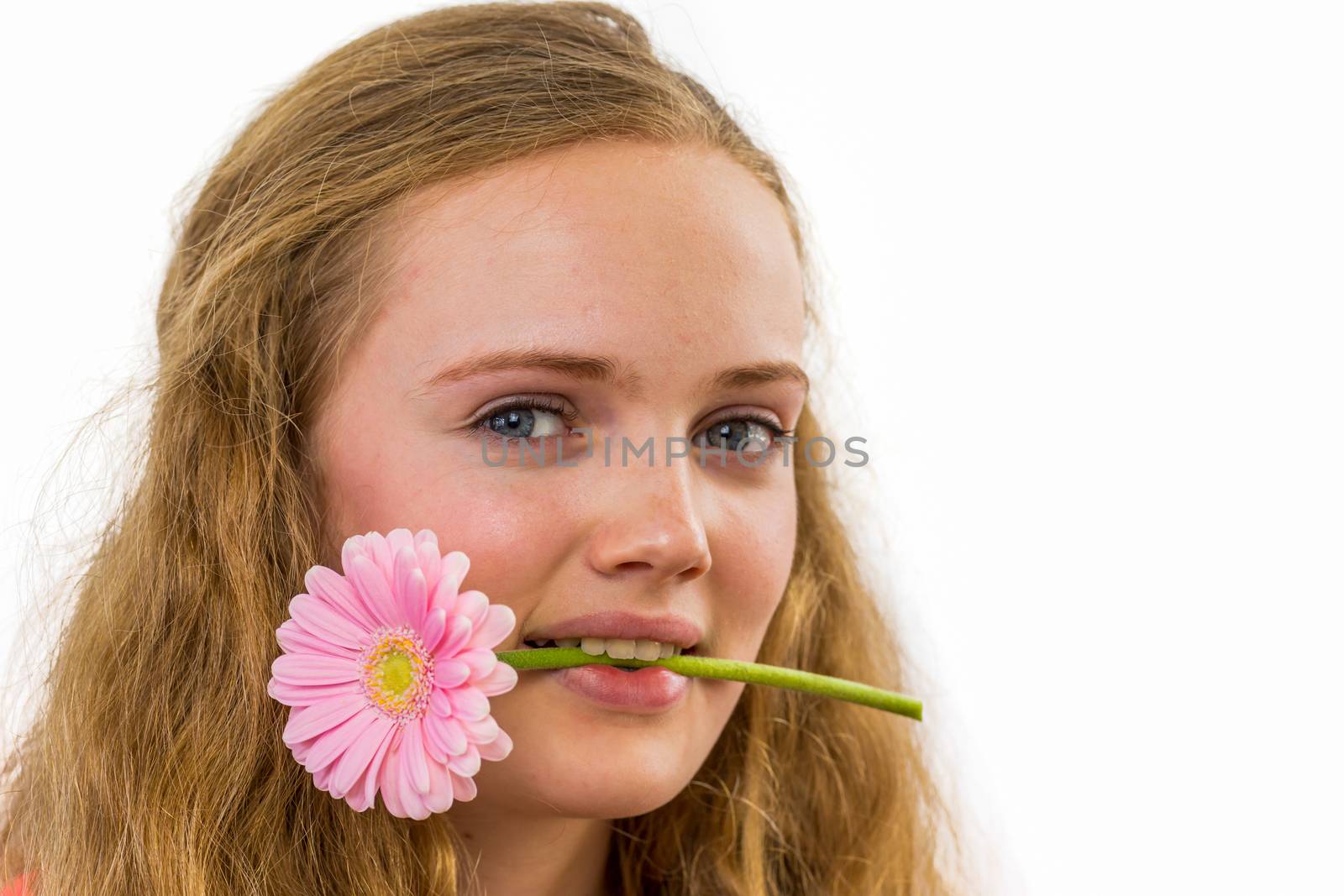 Face of european teenage girl with flower in her mouth isolated on white background