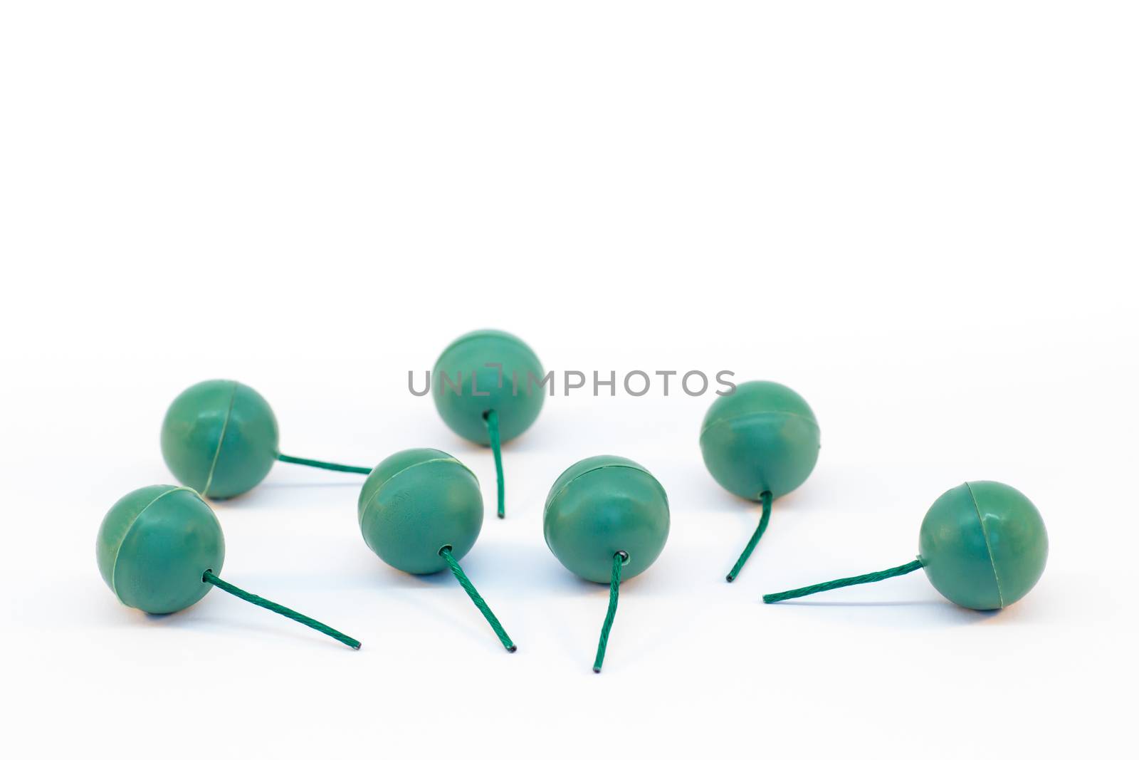 Green plastic balls as fireworks with fuses isolated on white background