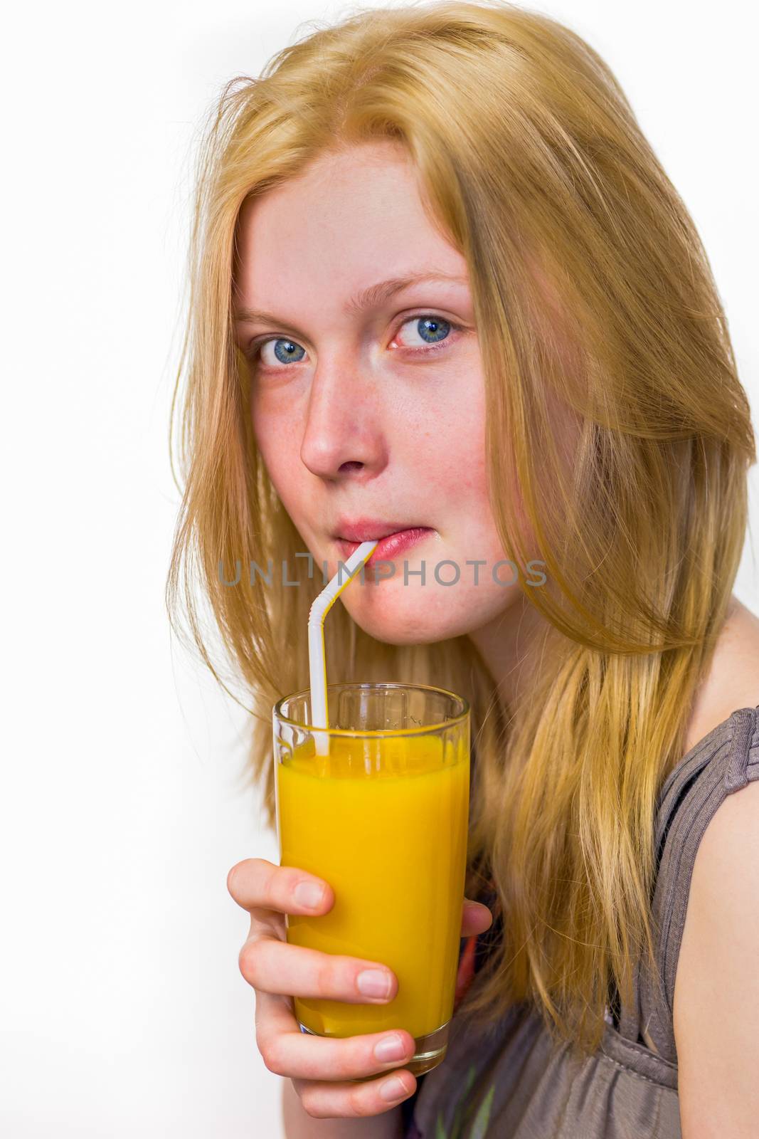 Blonde dutch teenage girl drinking orange juice with straw isolated on white background