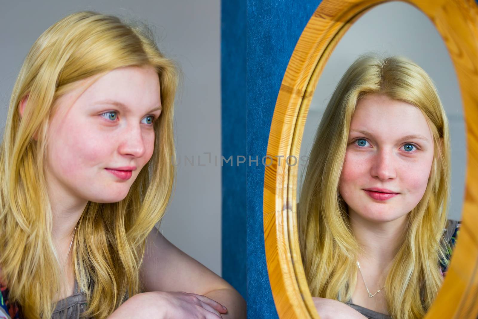 Blonde european teenage girl looking in mirror