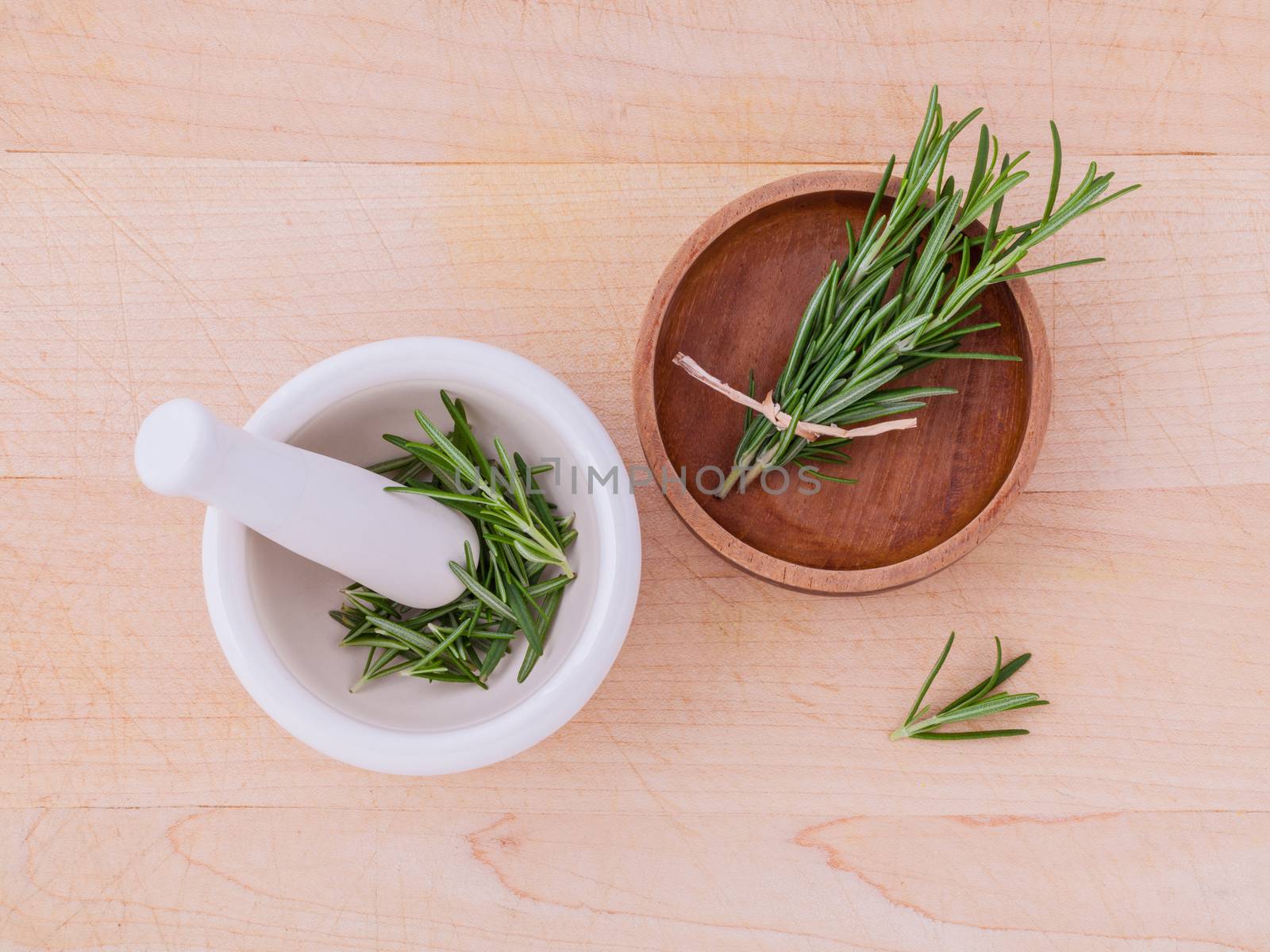 Fresh rosemary herbal medicine in mortar and wooden bowl on wood by kerdkanno