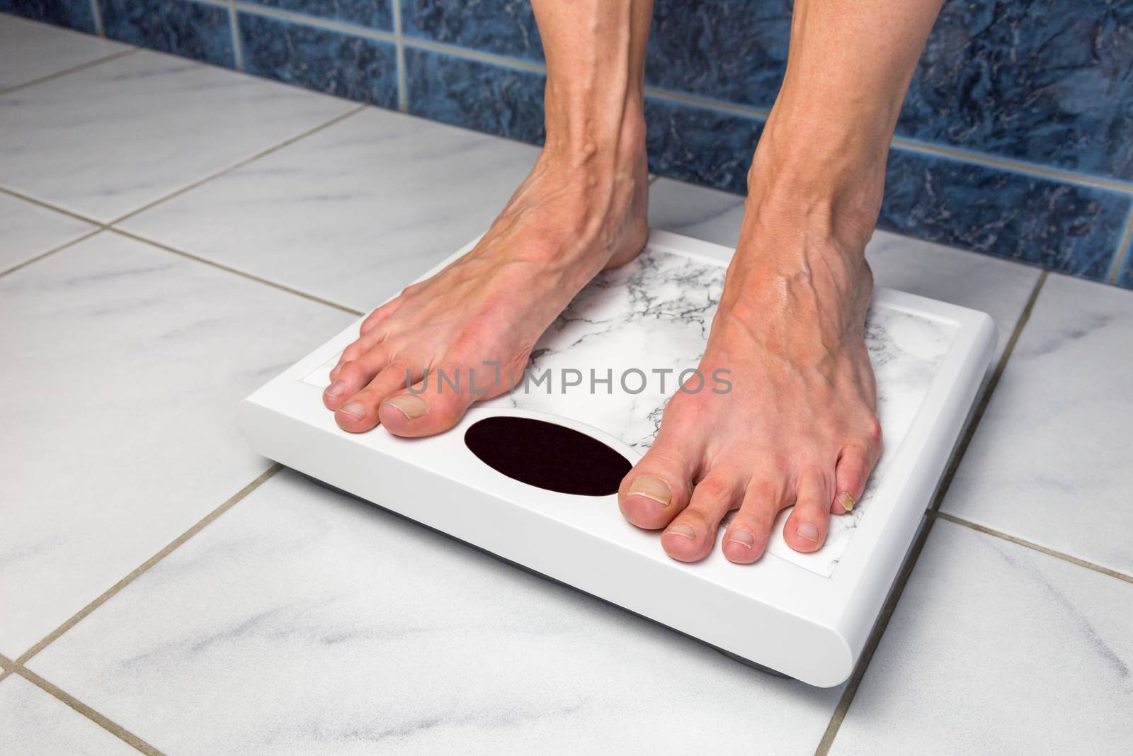 Female feet standing on bathroom scales for measuring body weight