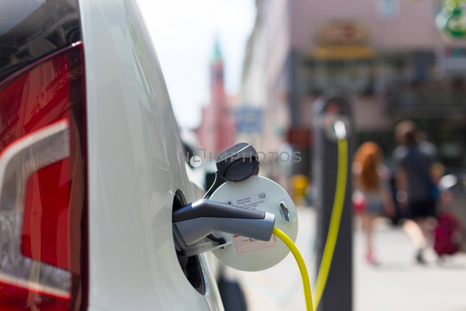 Power supply for electric car charging.  Electric car charging station. Close up of the power supply plugged into an electric car being charged.