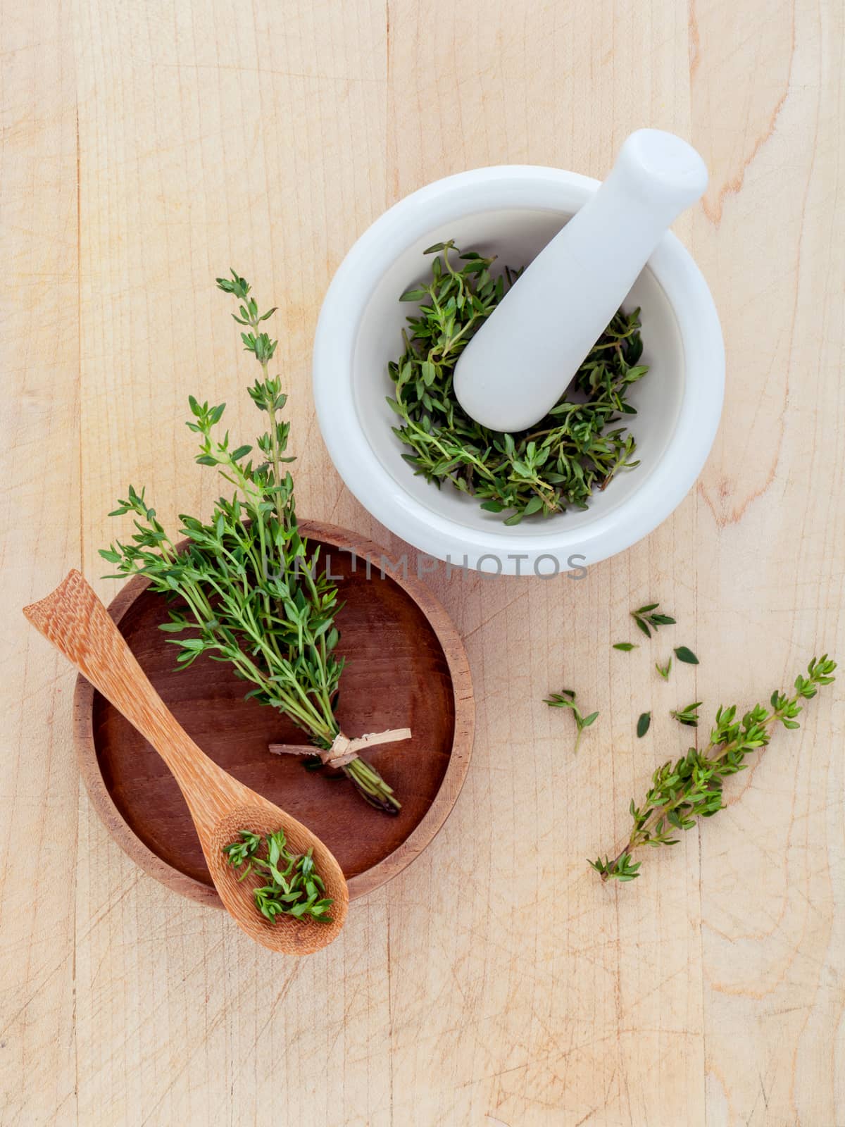 Bunch of fresh organic thyme in white mortar on wooden background
