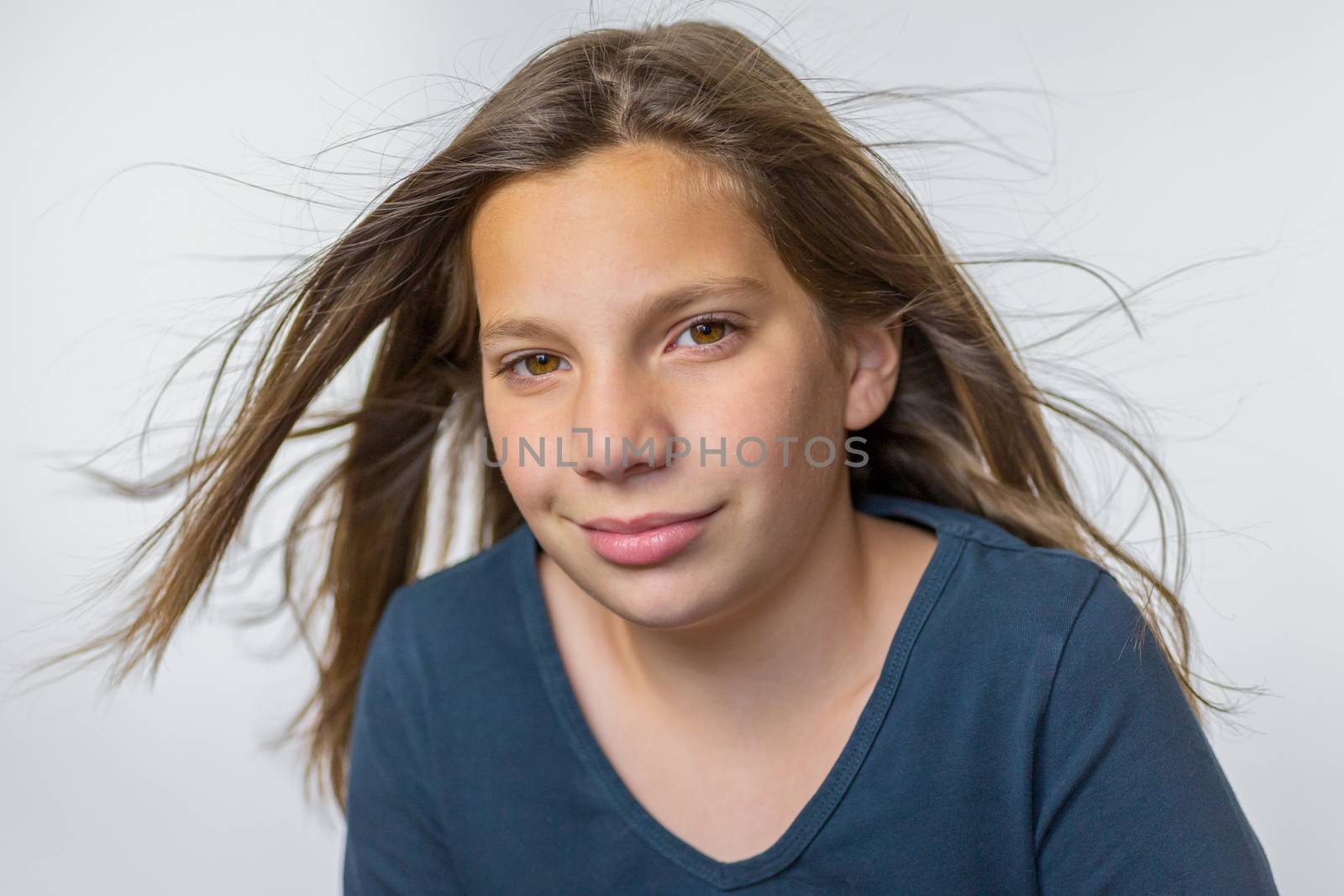 Caucasian teenage girl with long blown hair isolated on white background