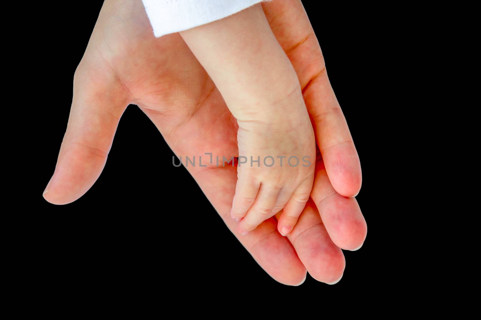 Hand of mother carrying arm of newborn baby isolated on black background