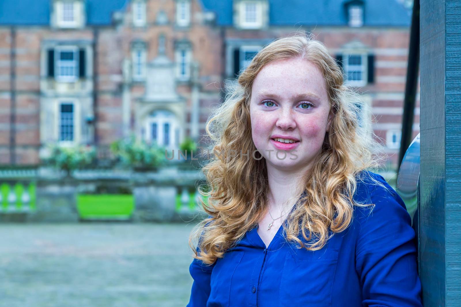 Portrait of european red haired teenage girl with castle on background