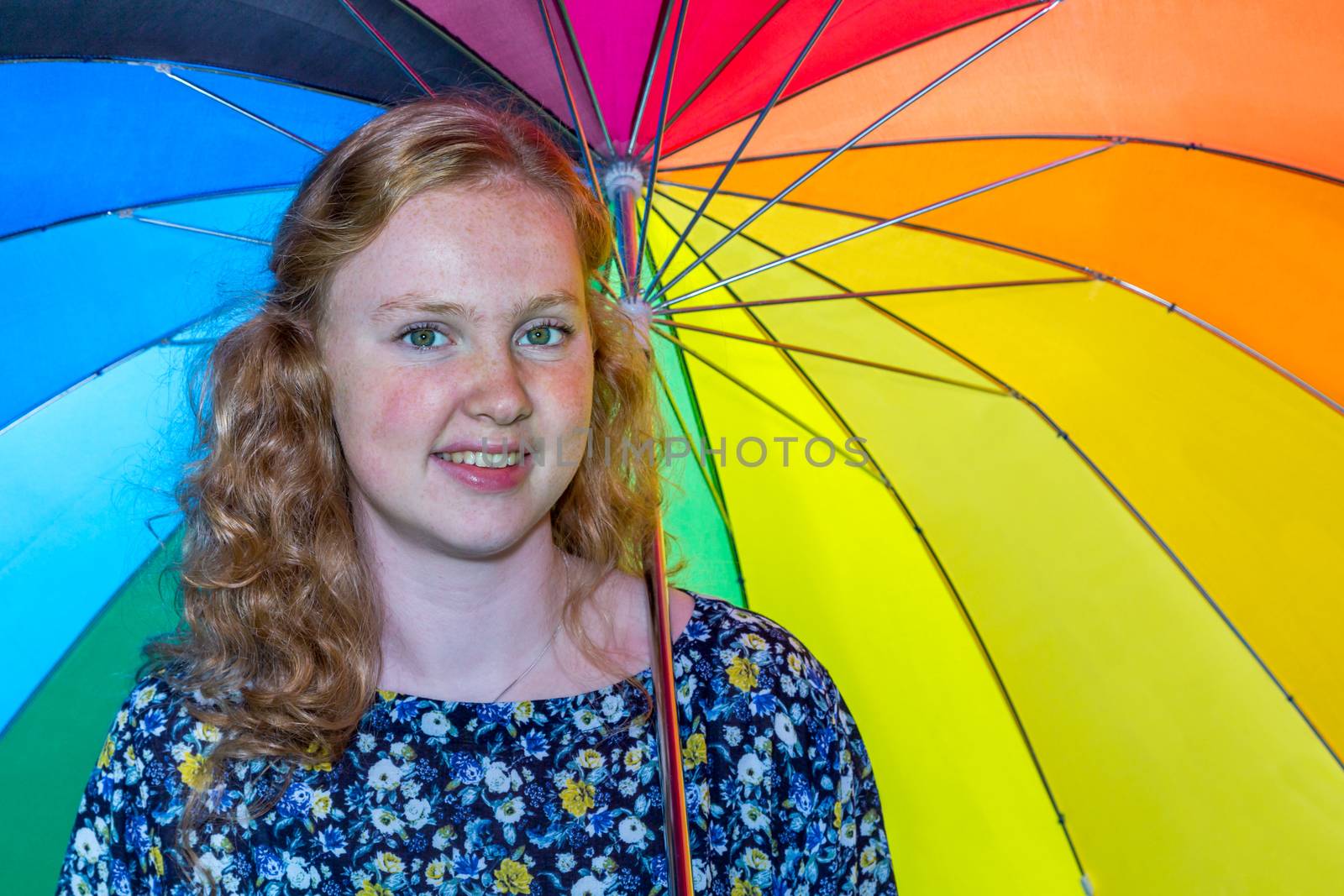 European teenage girl under colored umbrella