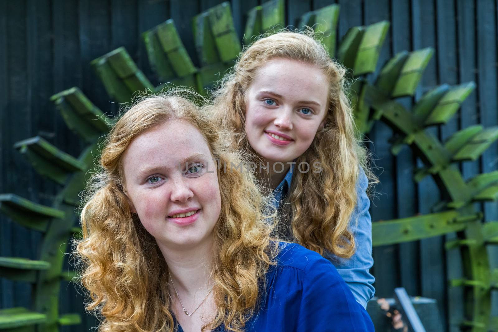 Two european teenage sisters in front of water mill