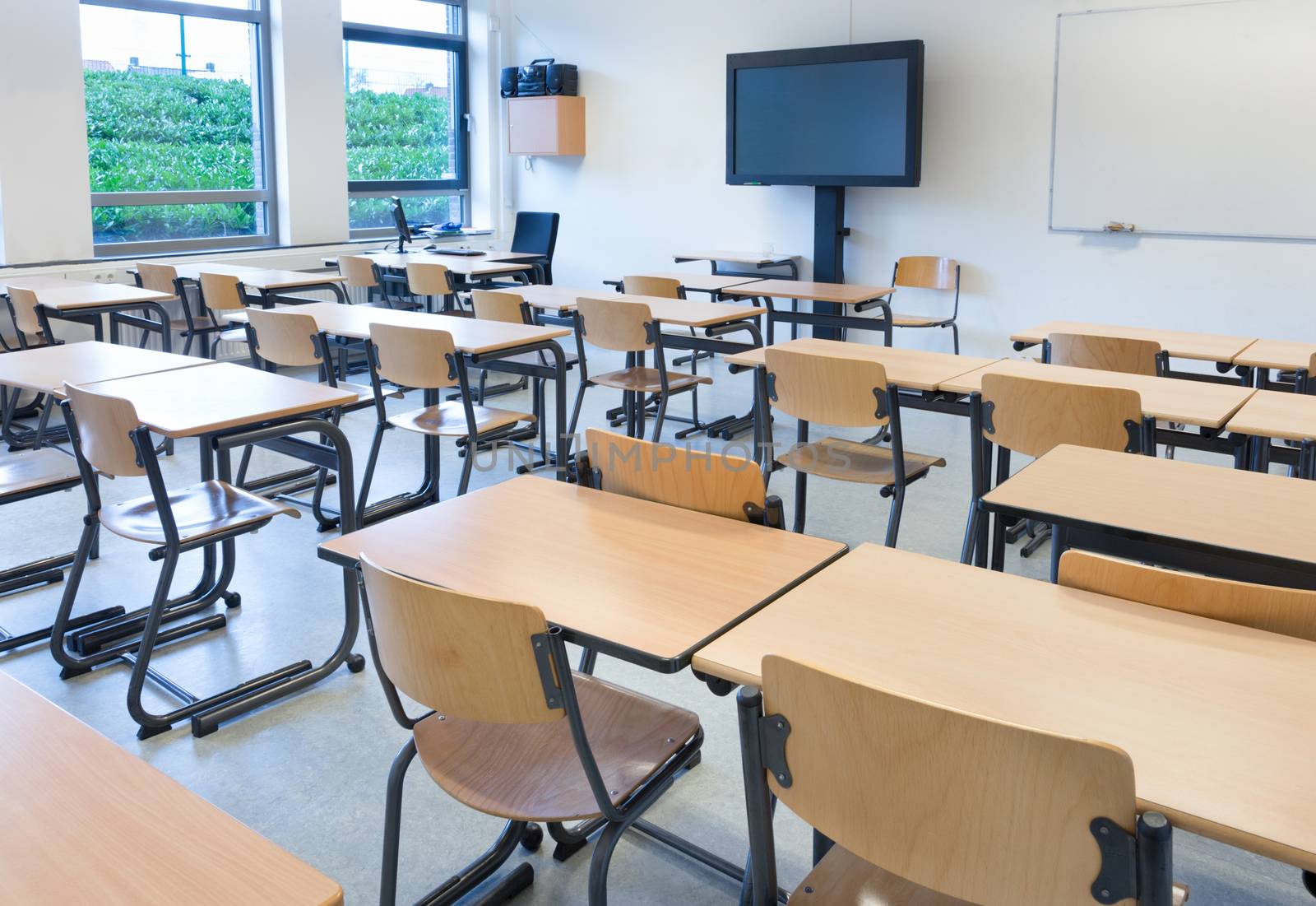 Empty classroom with tables and chairs in school building