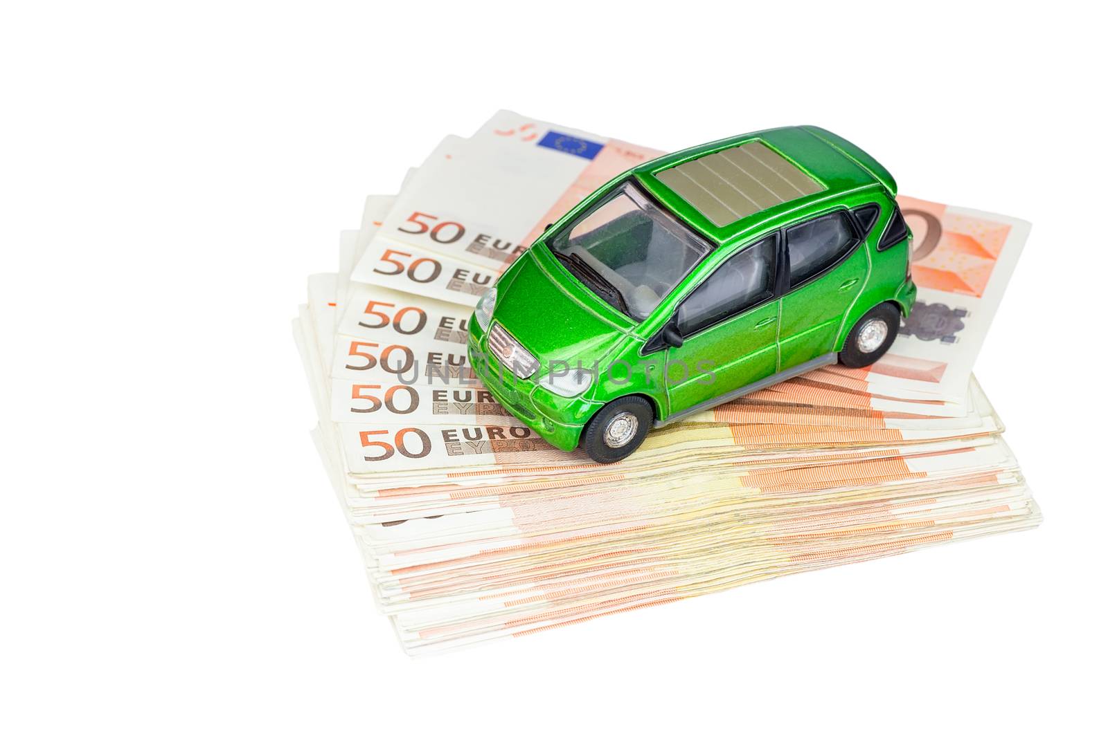 Green model car on stack of euro notes as symbol for buying or costs