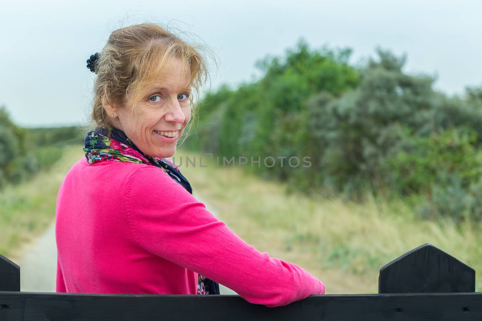 Portrait of middle aged caucasian woman at fence hiking in nature