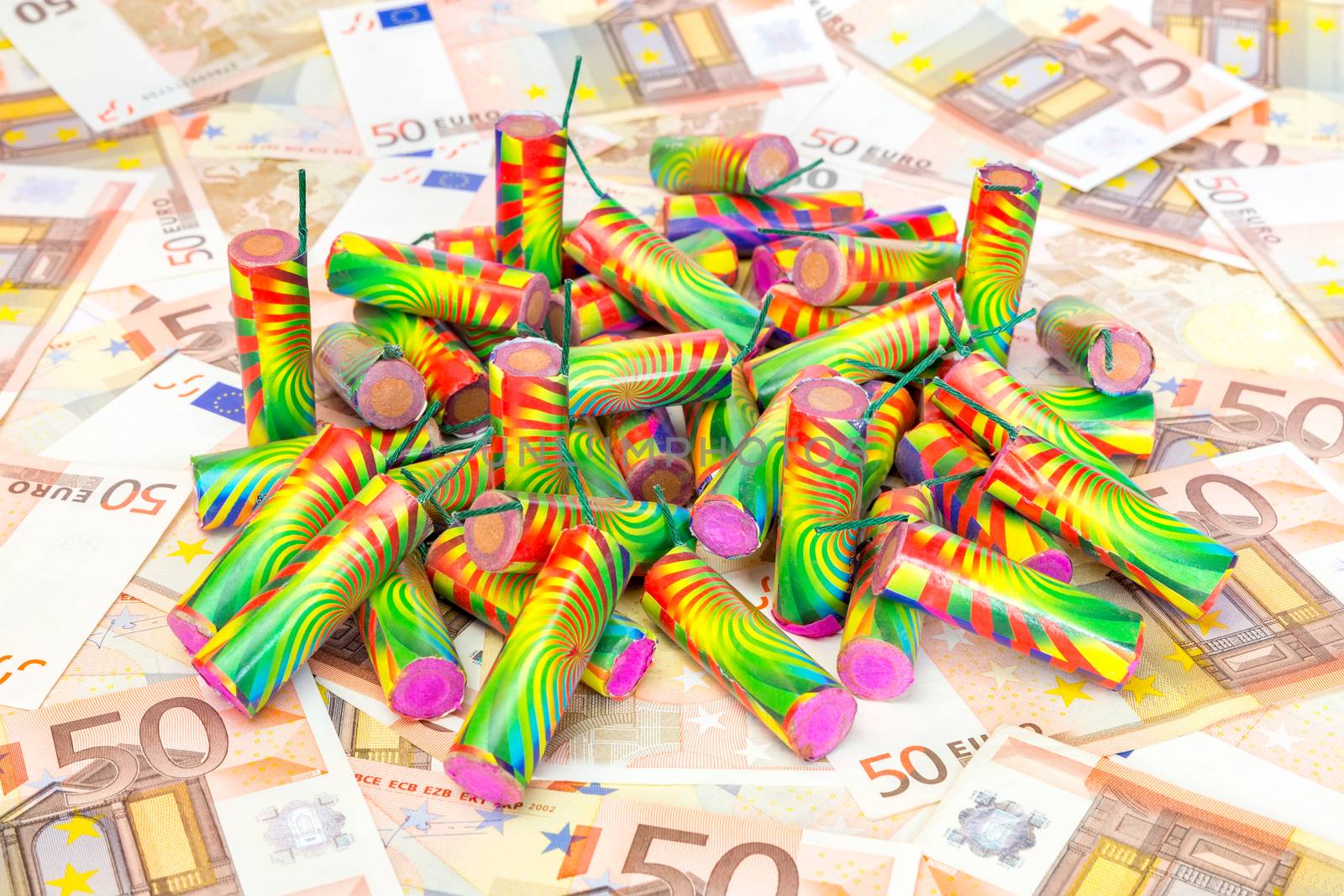 Stack of colorful fire work on spread euro bills