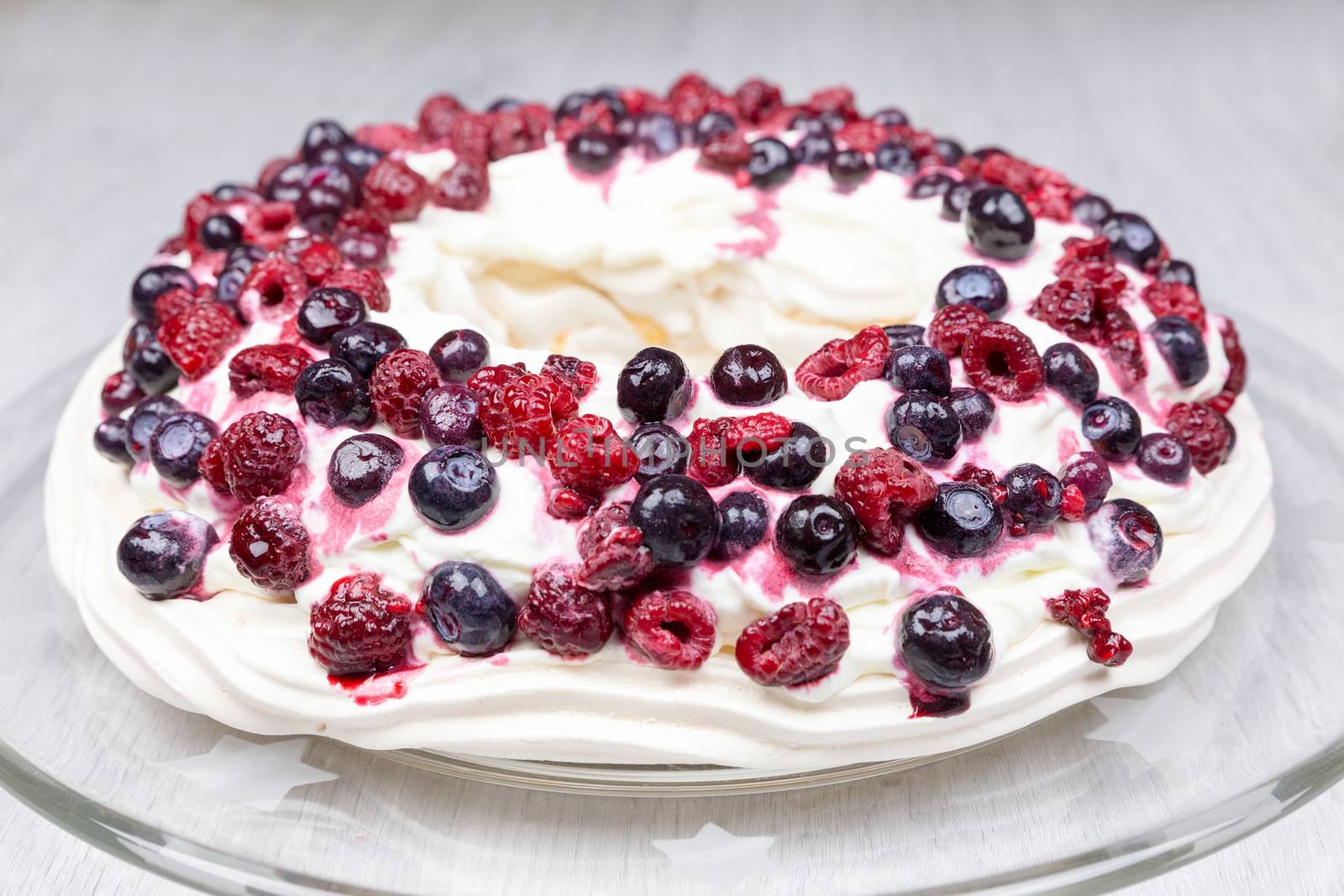 Raspberries and blueberries foam pie on glass scale by BenSchonewille