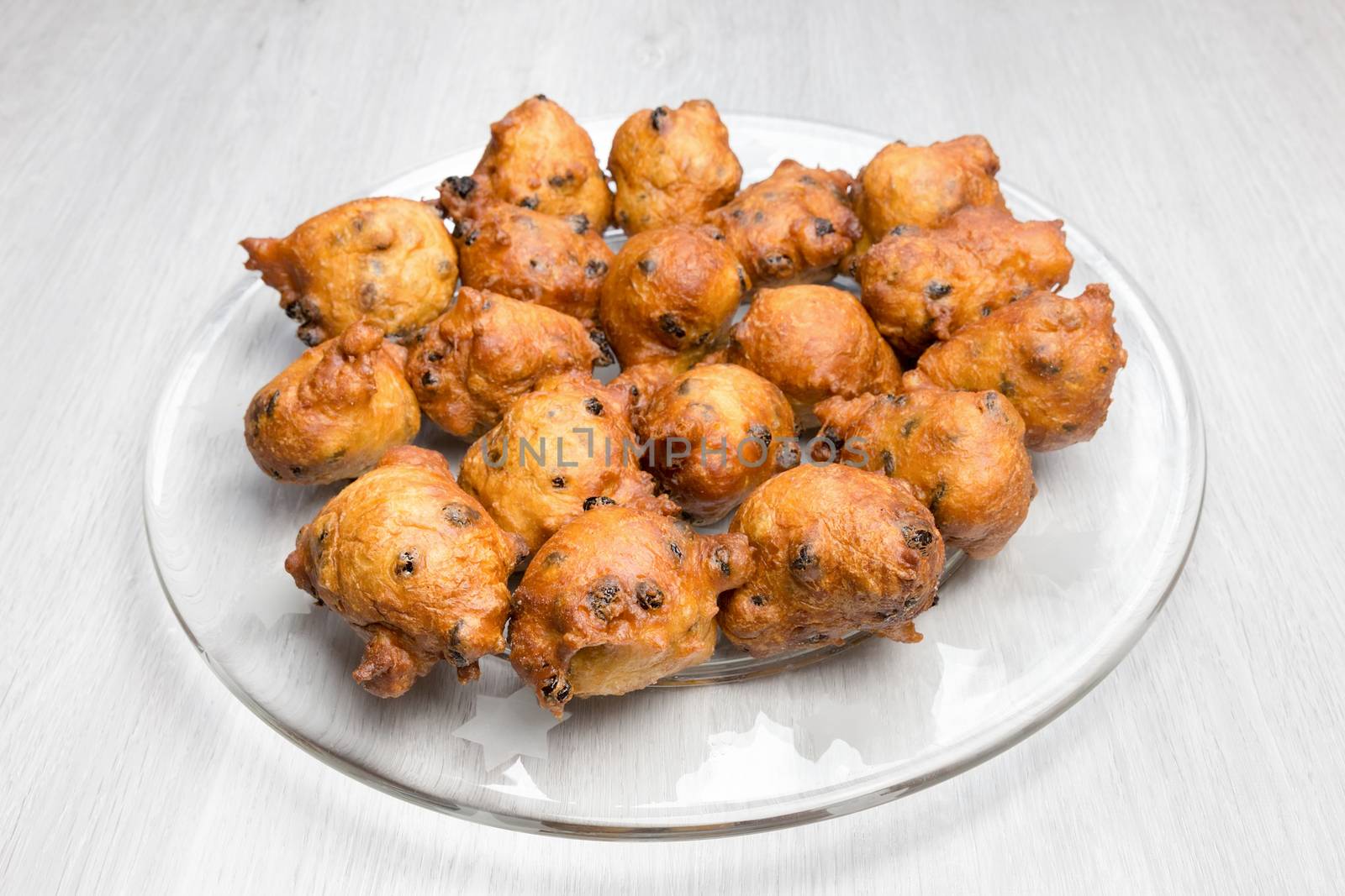 Fritters with raisins and currants on glass scale to celebrate old and new in Holland