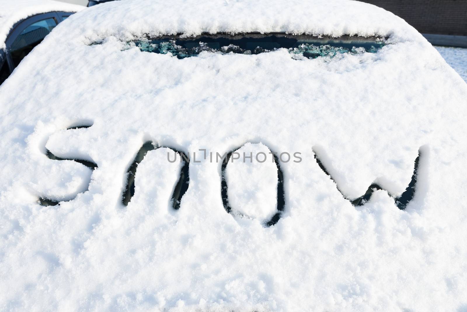 Word snow on windshield of car in winter season