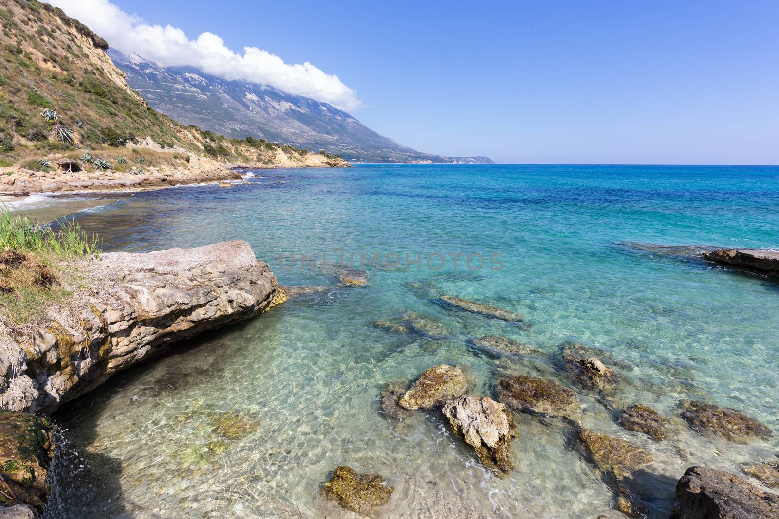 Coast with blue sea rocks and mountains in Greece by BenSchonewille