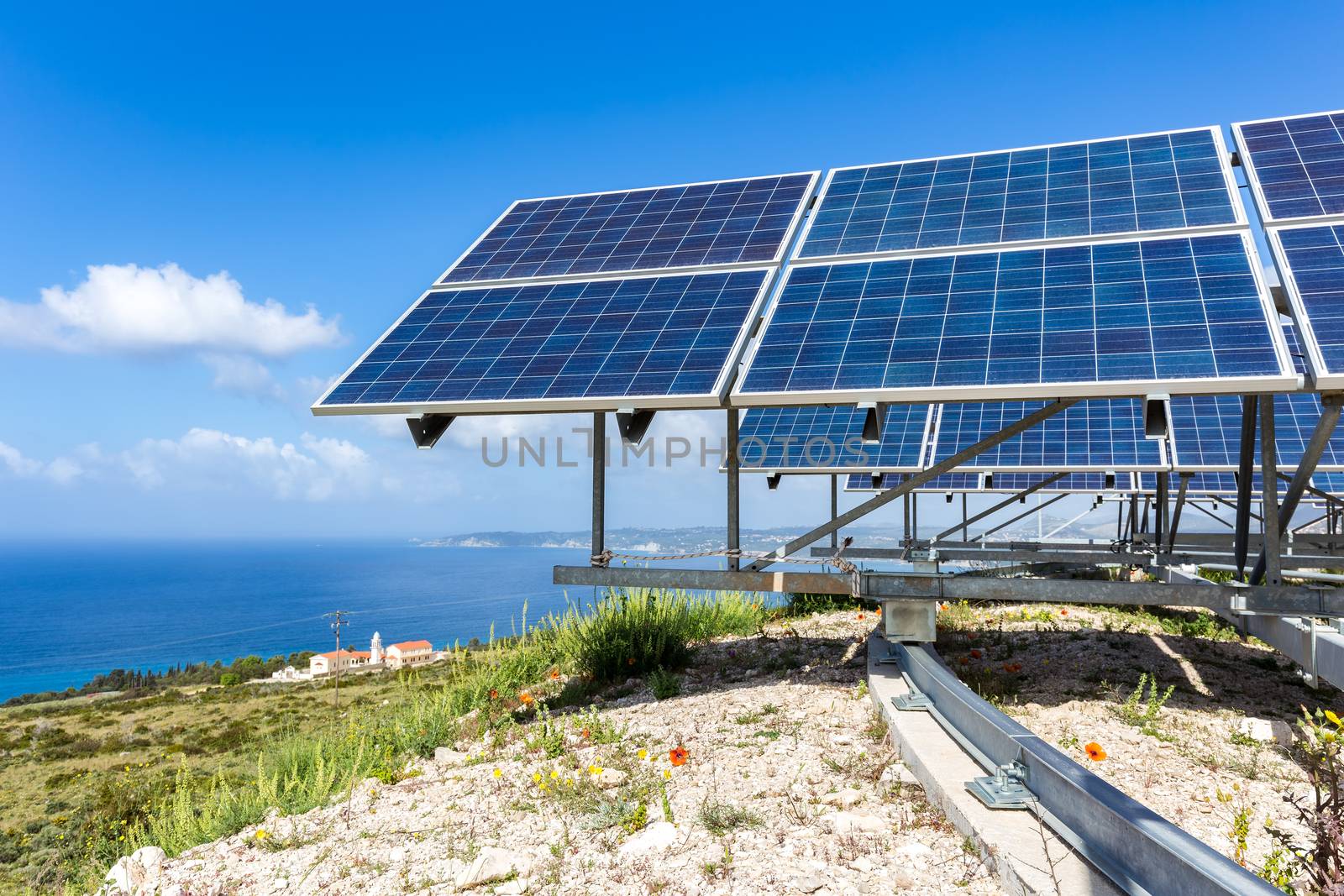 Many blue solar collectors near sea and monastry at coast in Kefalonia Greece