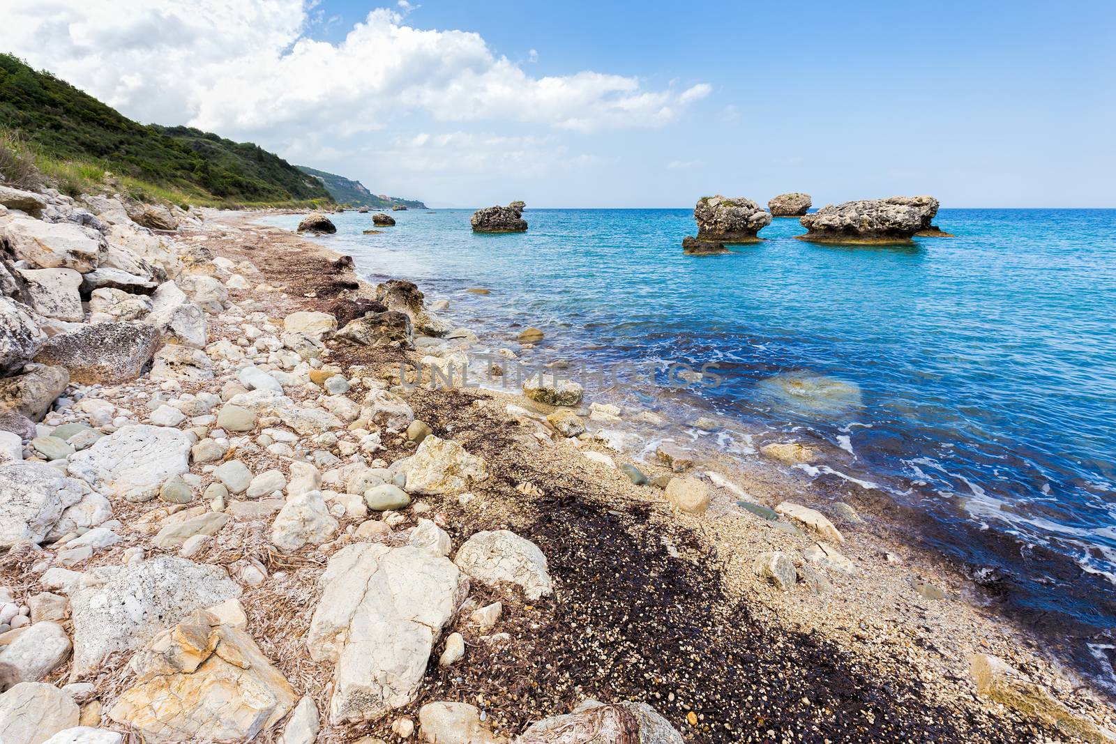 Landscape with boulders and rocks on coast with blue sea