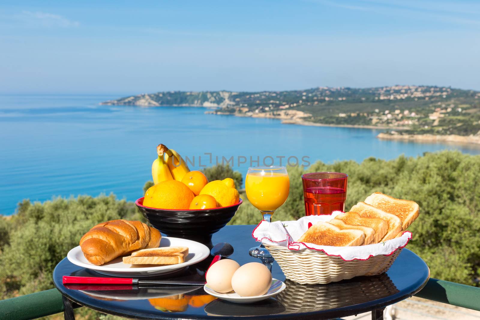 Table with food and drinks in front of sea on island Kefalonia in Greece